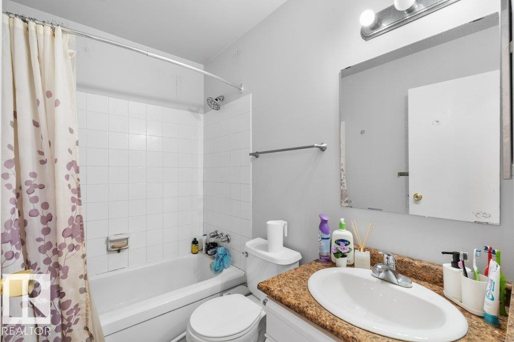 Bathroom with a bathtub and shower combination, white tiled walls, and a vanity with a granite-style countertop and an oval sink - 638 Saddleback Road, Edmonton, AB - Indoor Photo Showing Bathroom