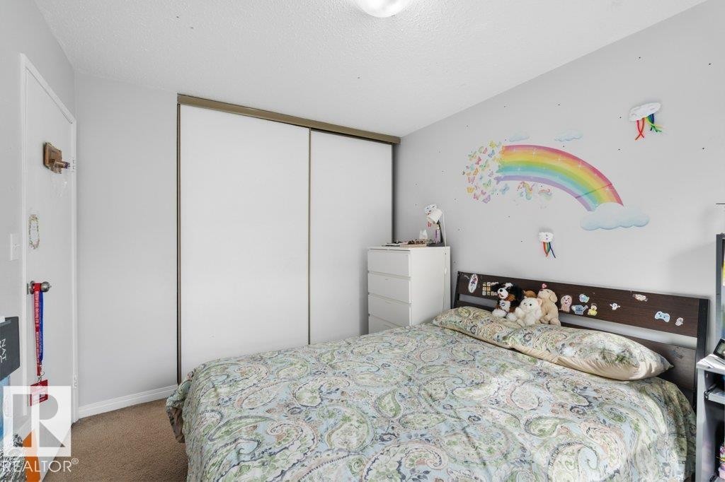 Bedroom featuring carpeted flooring and a built-in closet with sliding doors - 638 Saddleback Road, Edmonton, AB - Indoor Photo Showing Bedroom