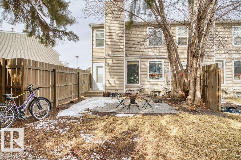 The property features a fenced backyard with a patio area and mature trees - 638 Saddleback Road, Edmonton, AB - Outdoor