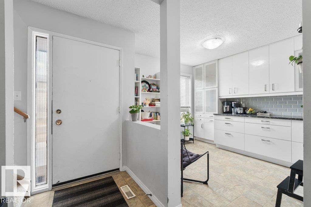 The property features a bright entrance with a white door and a full-length sidelight, leading into a space with tiled flooring - 638 Saddleback Road, Edmonton, AB - Indoor Photo Showing Other Room