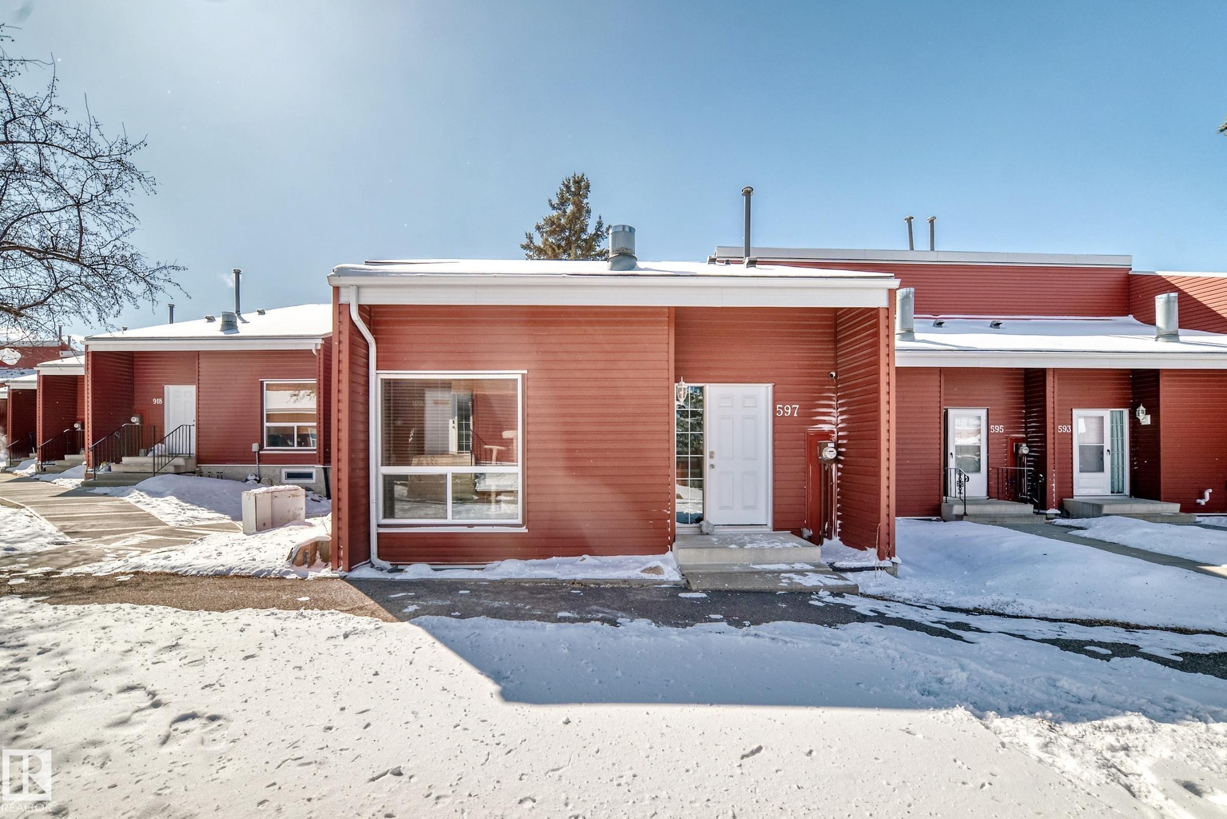 The property features a red exterior with white trim and a white front door - 597 Millbourne Road E, Edmonton, AB - Outdoor