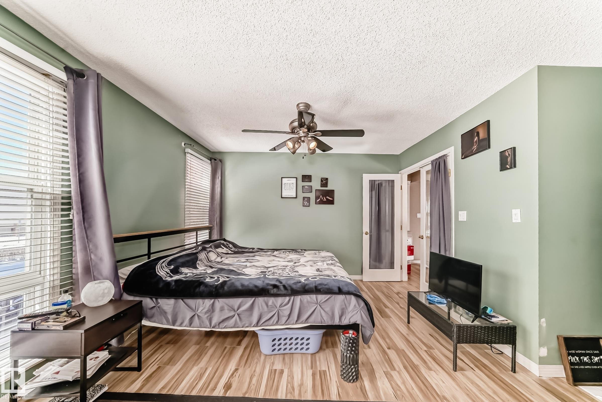 This room features light green walls, wood-look flooring, and a ceiling fan - 597 Millbourne Road E, Edmonton, AB - Indoor Photo Showing Bedroom