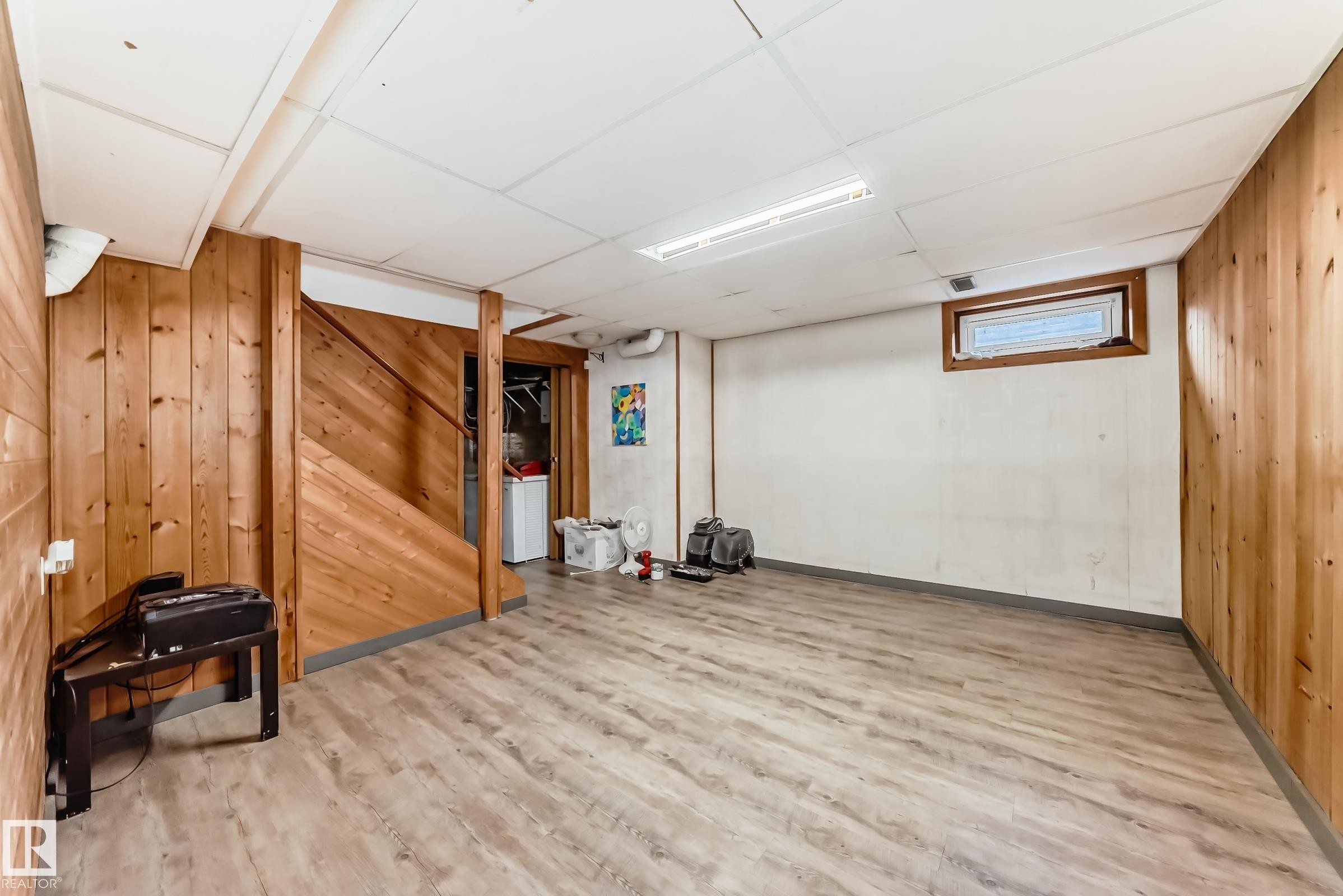 This versatile space features wood paneling, wood-look flooring, and a window - 597 Millbourne Road E, Edmonton, AB - Indoor Photo Showing Other Room