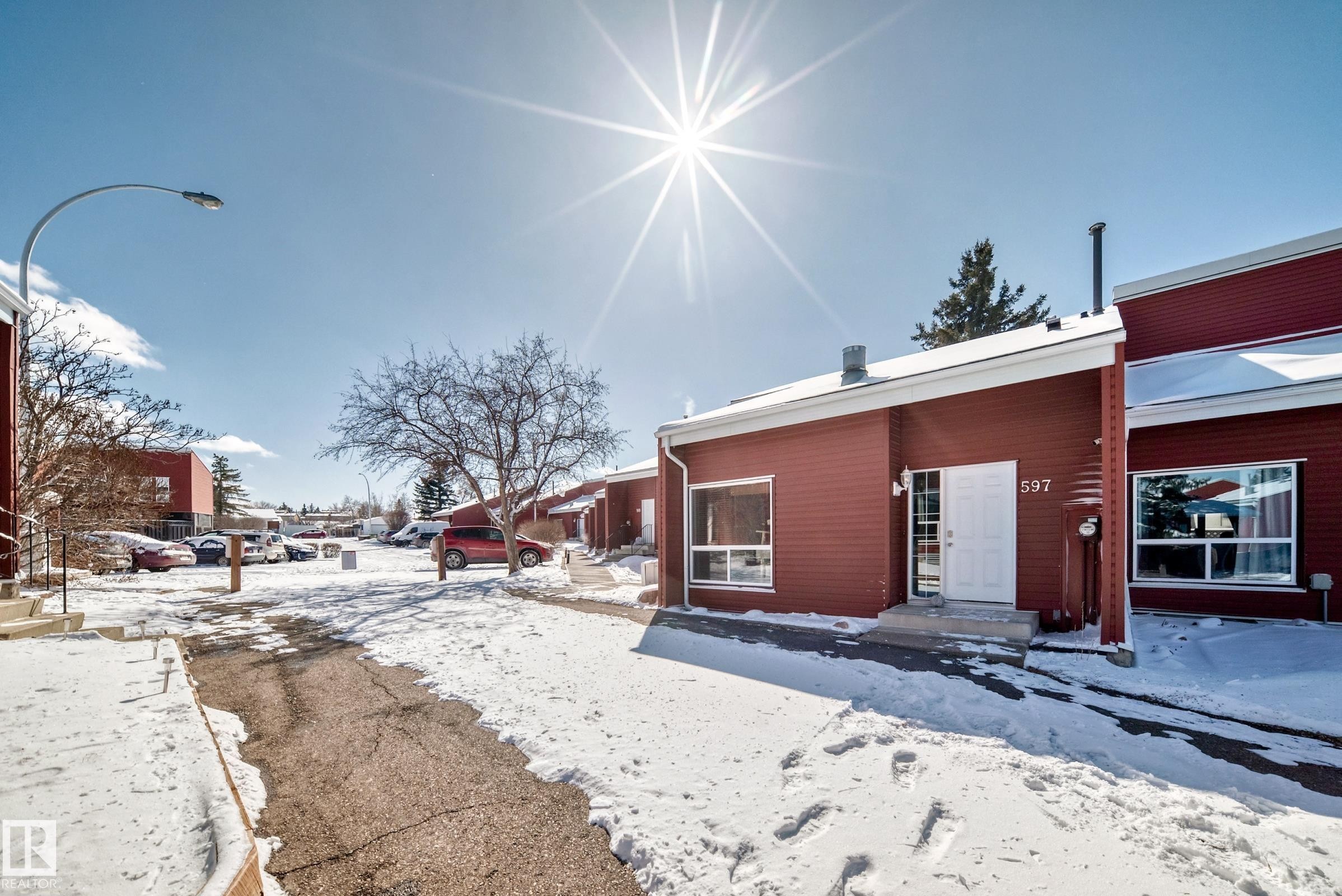 The property features a red exterior with white trim and a white front door - 597 Millbourne Road E, Edmonton, AB - Outdoor