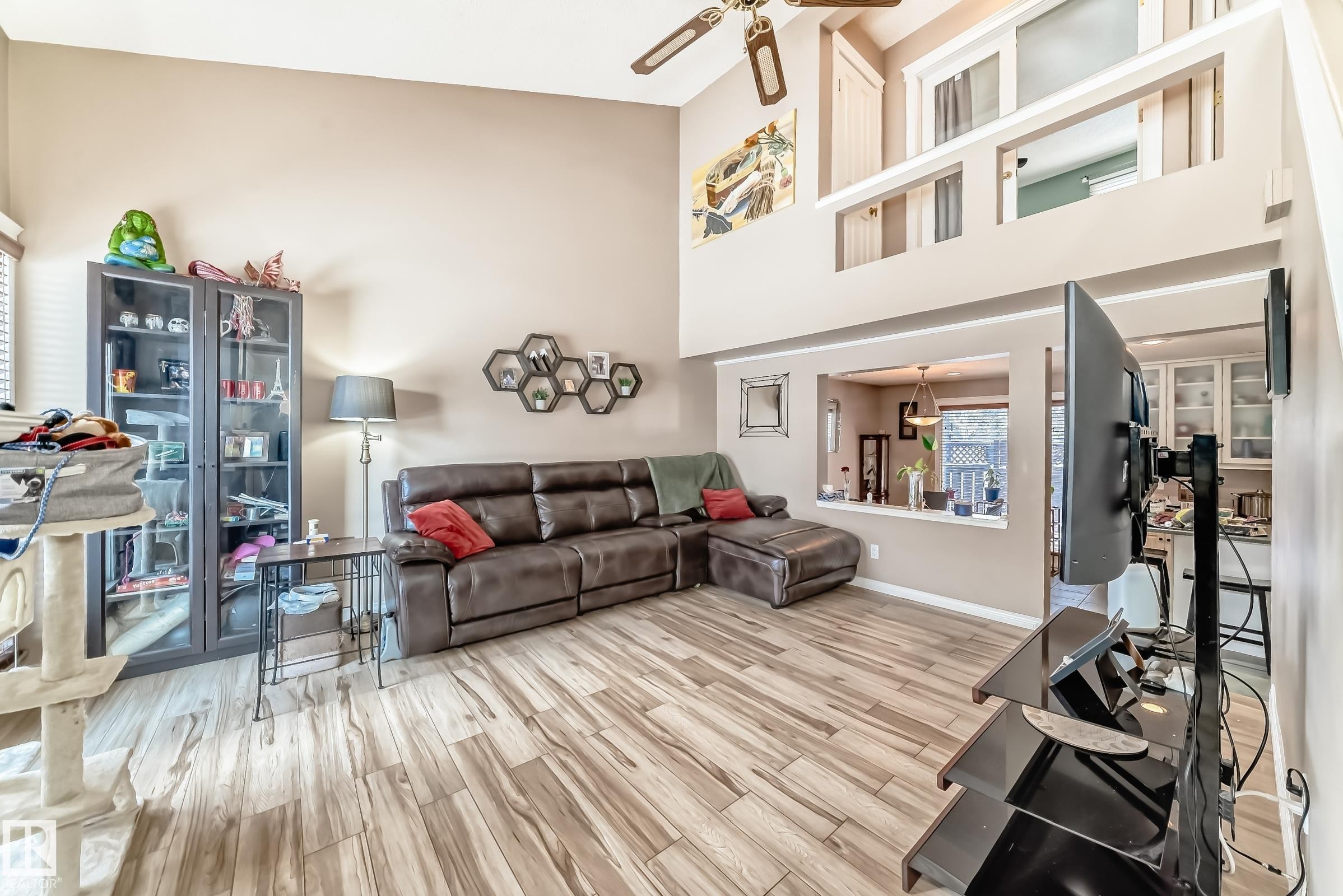 Living area featuring vaulted ceilings, wood-look flooring, and a ceiling fan - 597 Millbourne Road E, Edmonton, AB - Indoor