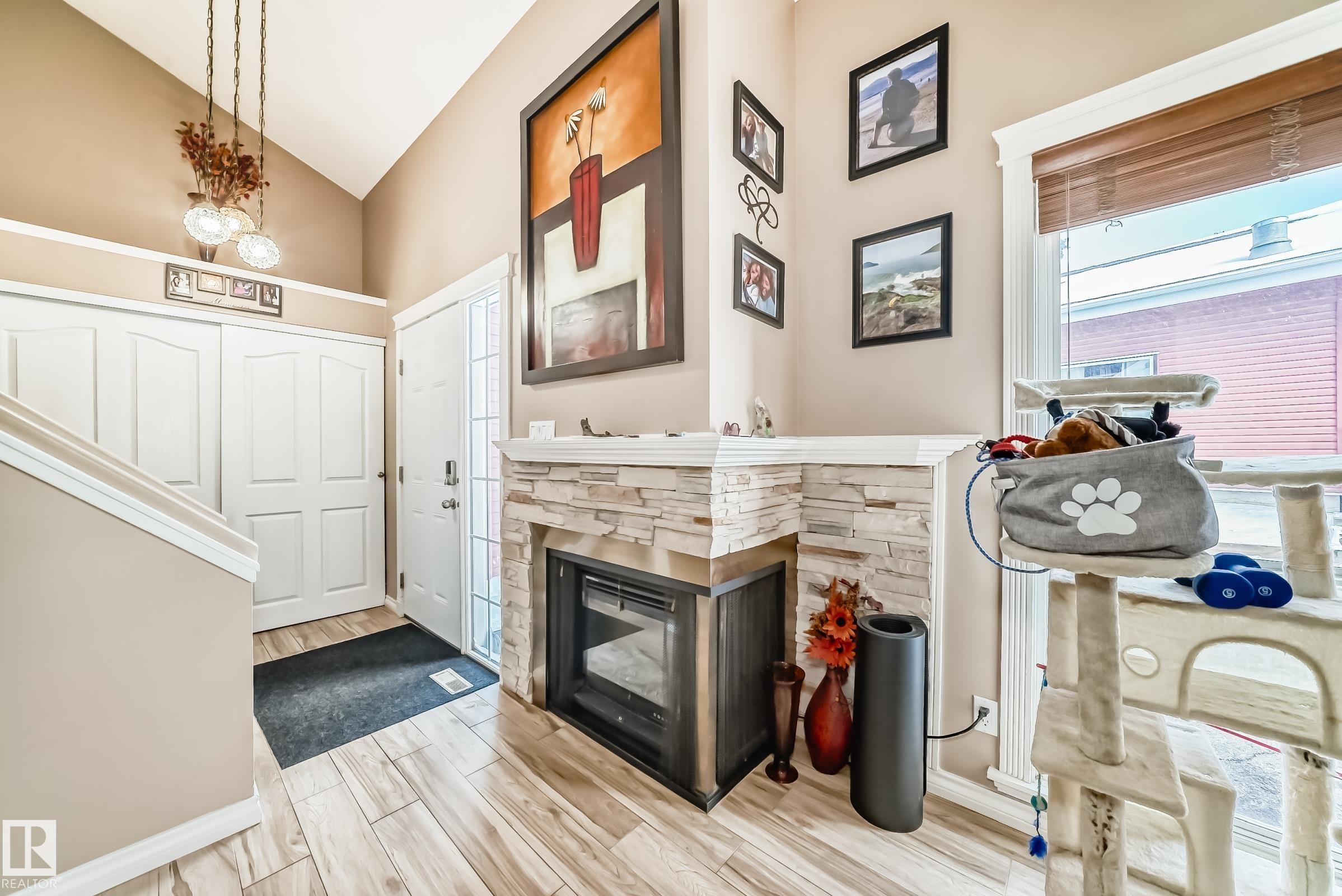 The entryway features a stone-clad fireplace and light-toned flooring - 597 Millbourne Road E, Edmonton, AB - Indoor Photo Showing Other Room With Fireplace