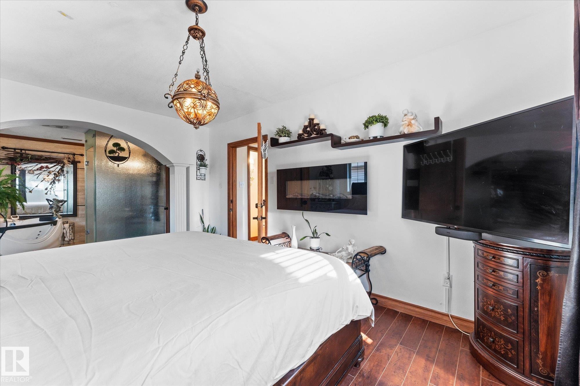 This room features hardwood floors and a decorative chandelier - 11124 110A Avenue, Edmonton, AB - Indoor Photo Showing Bedroom