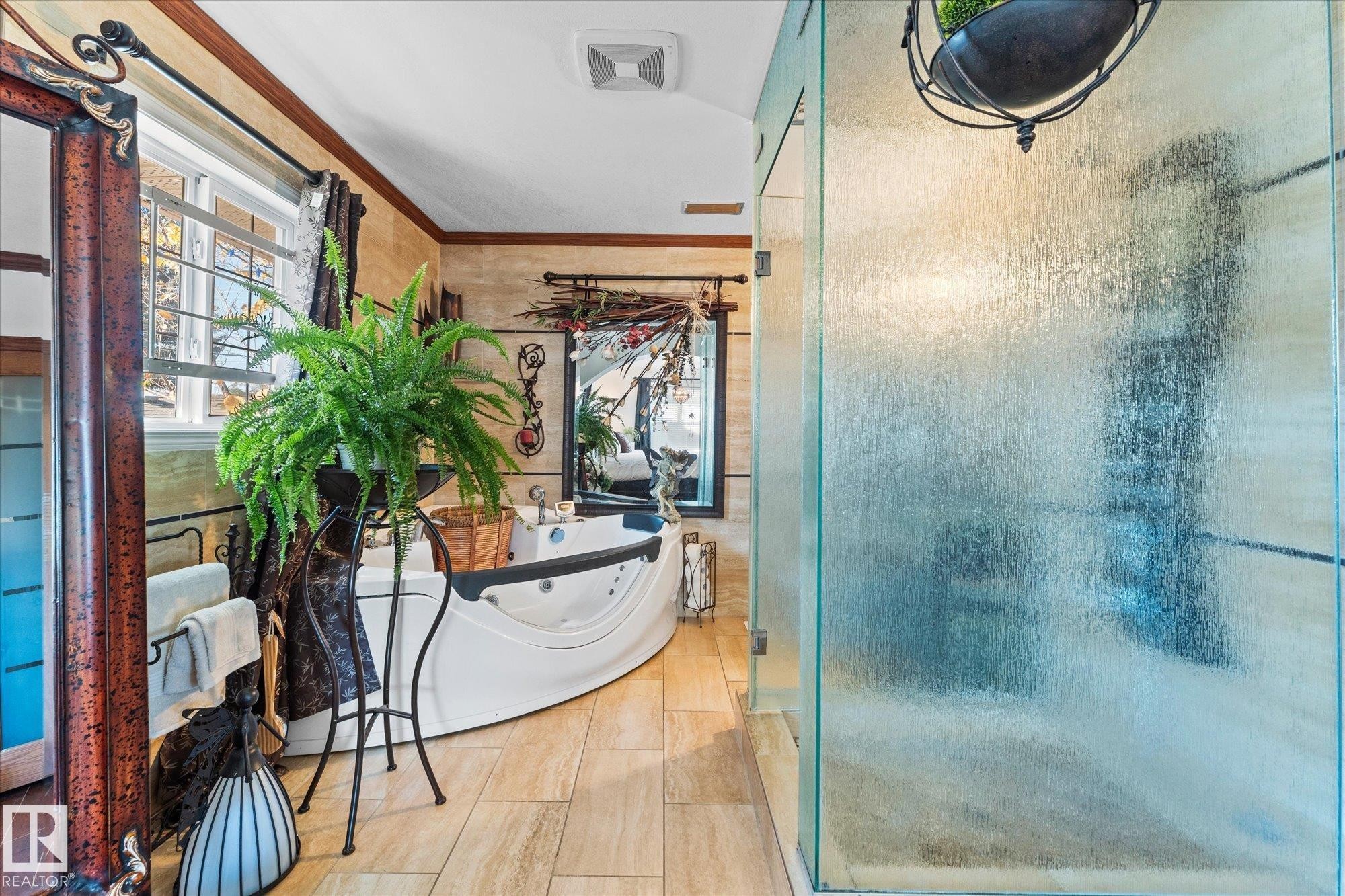 The bathroom features a spacious soaking tub, large windows providing natural light, and a separate glass-enclosed shower - 11124 110A Avenue, Edmonton, AB - Indoor Photo Showing Bathroom