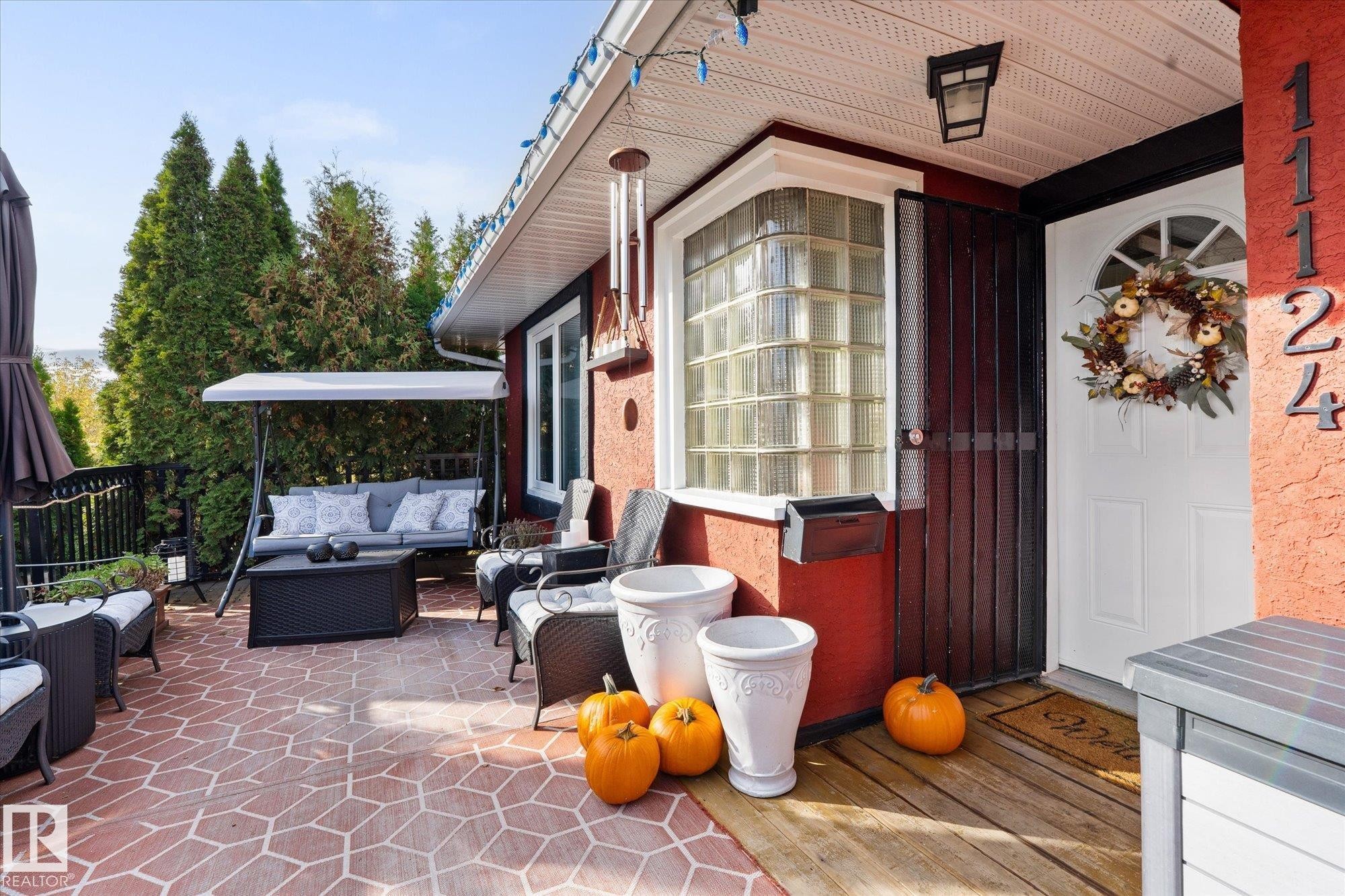 The property features a front patio with a patterned brick surface and a porch area with wooden flooring - 11124 110A Avenue, Edmonton, AB - Outdoor With Deck Patio Veranda With Exterior