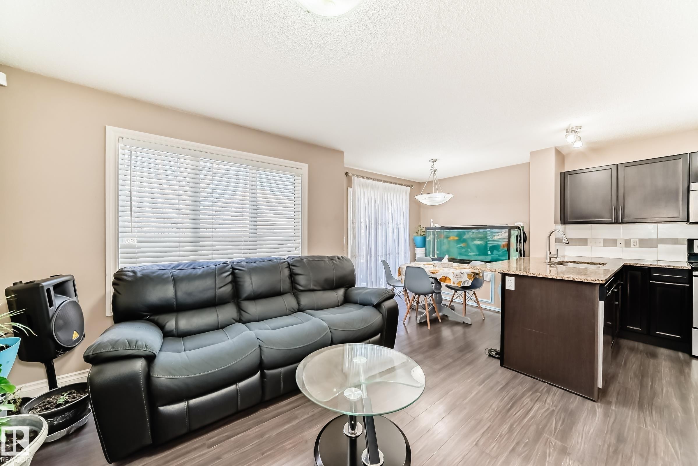 This property features an open concept living area with dark wood-look flooring throughout - 23 445 Brintnell Boulevard Nw, Edmonton, AB - Indoor Photo Showing Other Room