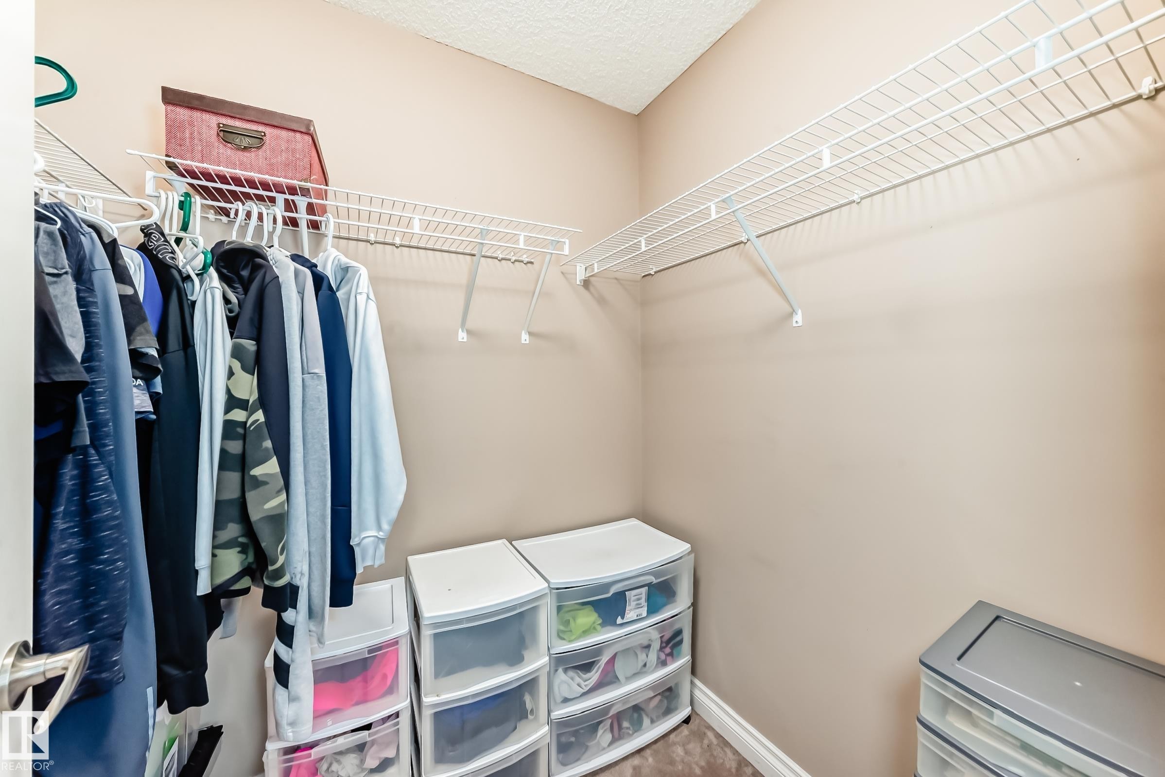 Walk-in closet featuring wire shelving and hanging rods - 23 445 Brintnell Boulevard Nw, Edmonton, AB - Indoor With Storage