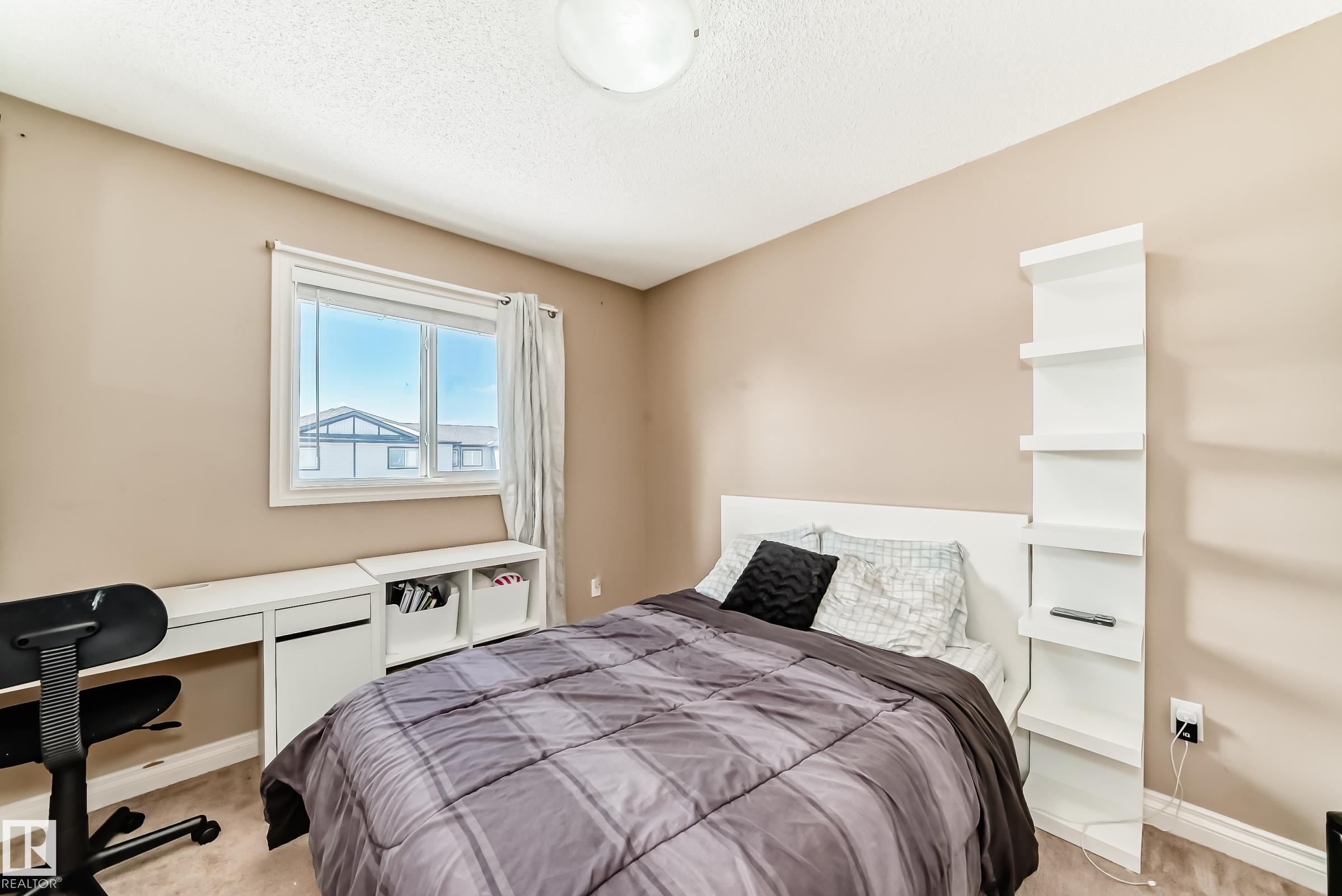 This room features a window with white trim, light-colored walls, and a ceiling light fixture - 23 445 Brintnell Boulevard Nw, Edmonton, AB - Indoor Photo Showing Bedroom