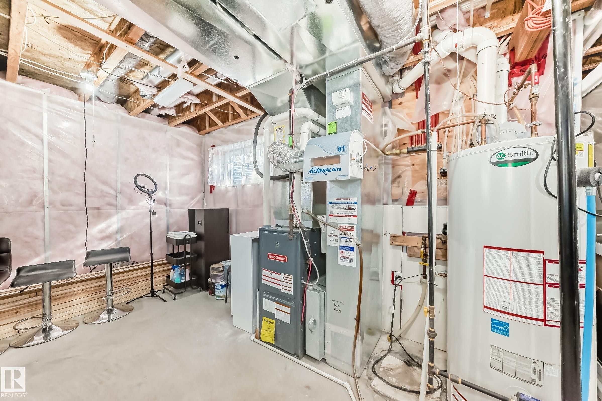 Utility area featuring a furnace, hot water heater, and exposed ceiling joists - 23 445 Brintnell Boulevard Nw, Edmonton, AB - Indoor Photo Showing Basement