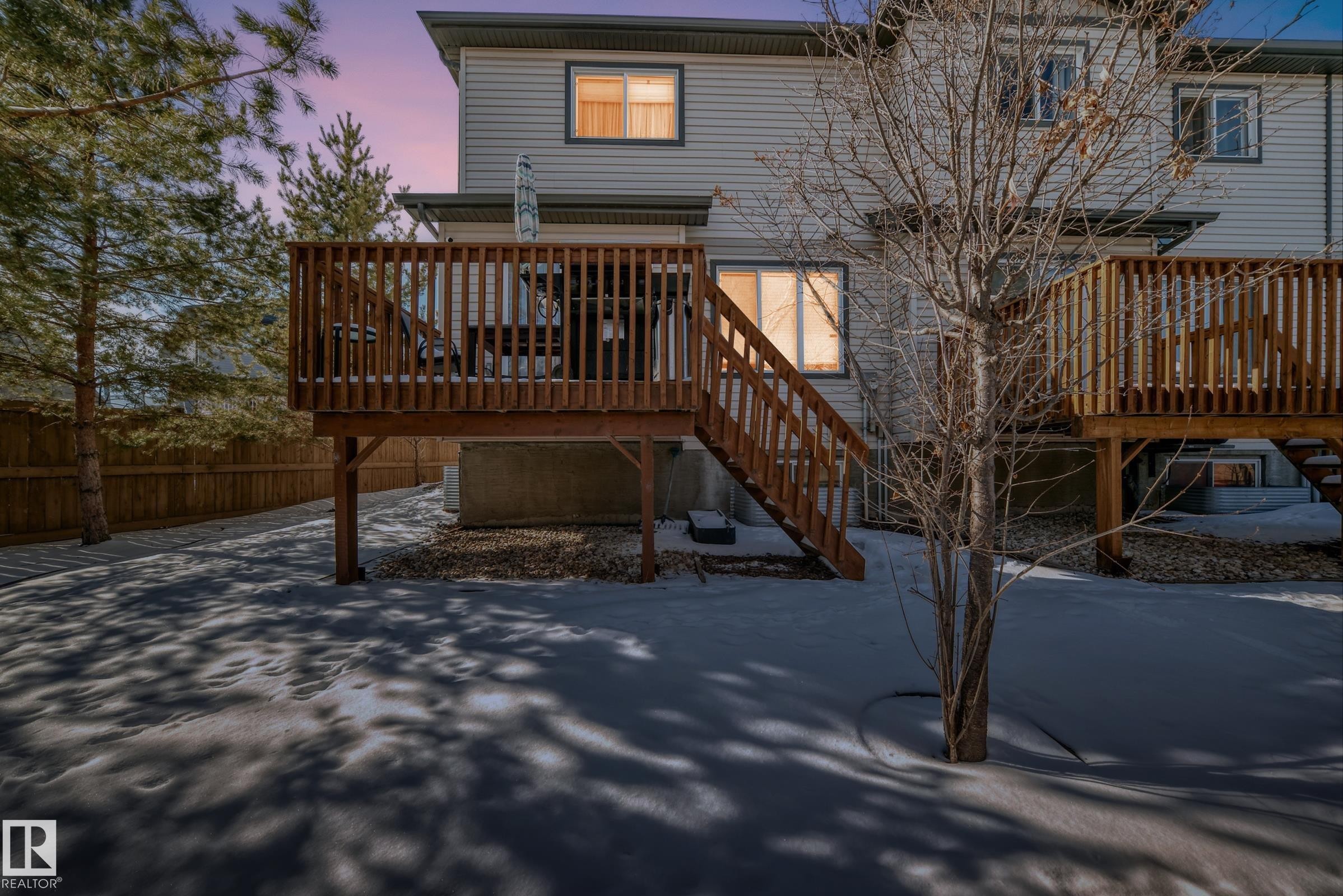 The property features a private wooden deck accessible via stairs, with a second-story deck also visible - 23 445 Brintnell Boulevard Nw, Edmonton, AB - Outdoor With Deck Patio Veranda