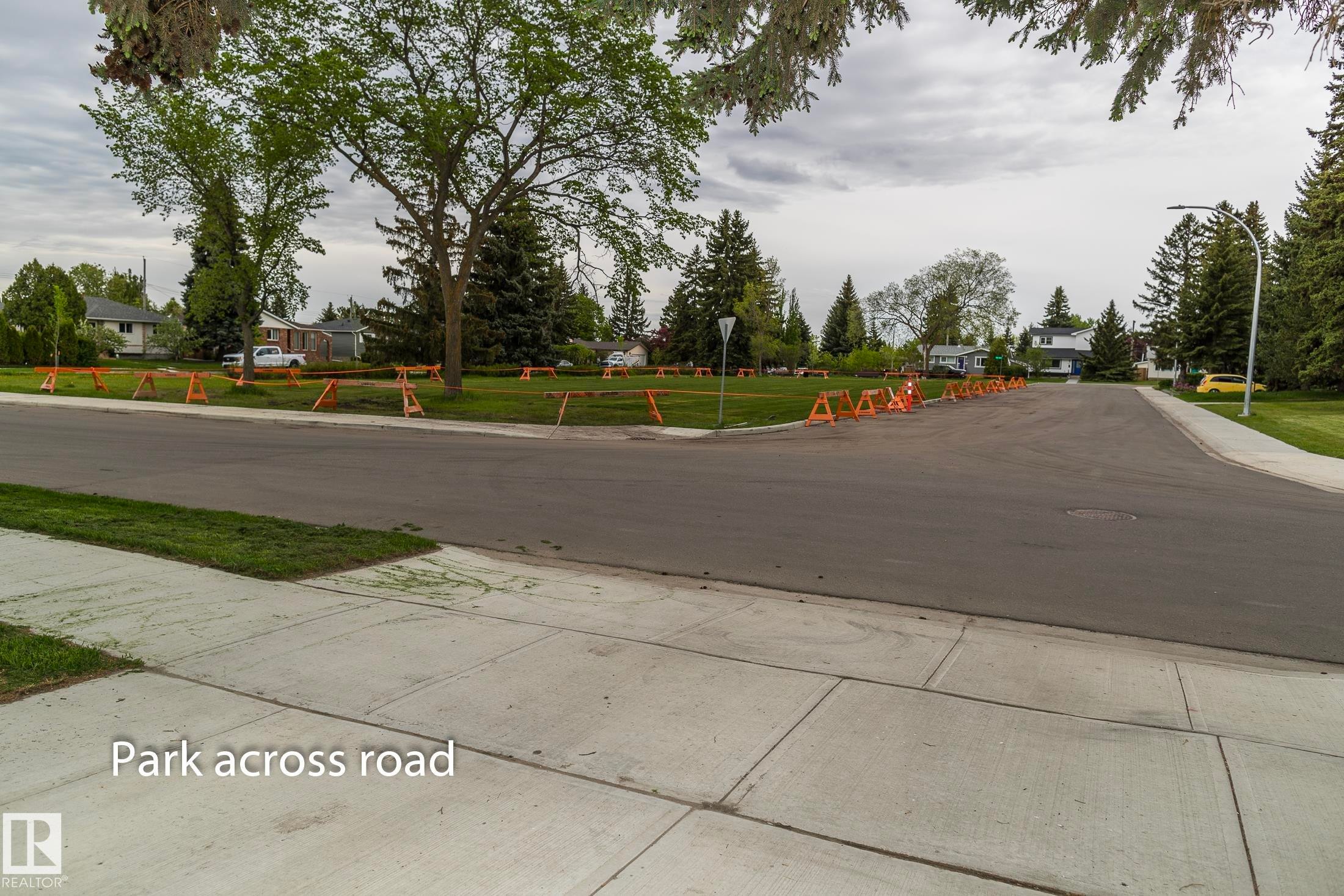 The property offers views of the park across the road, featuring mature trees and a grassy expanse - 10512 55 Avenue, Edmonton, AB - Outdoor