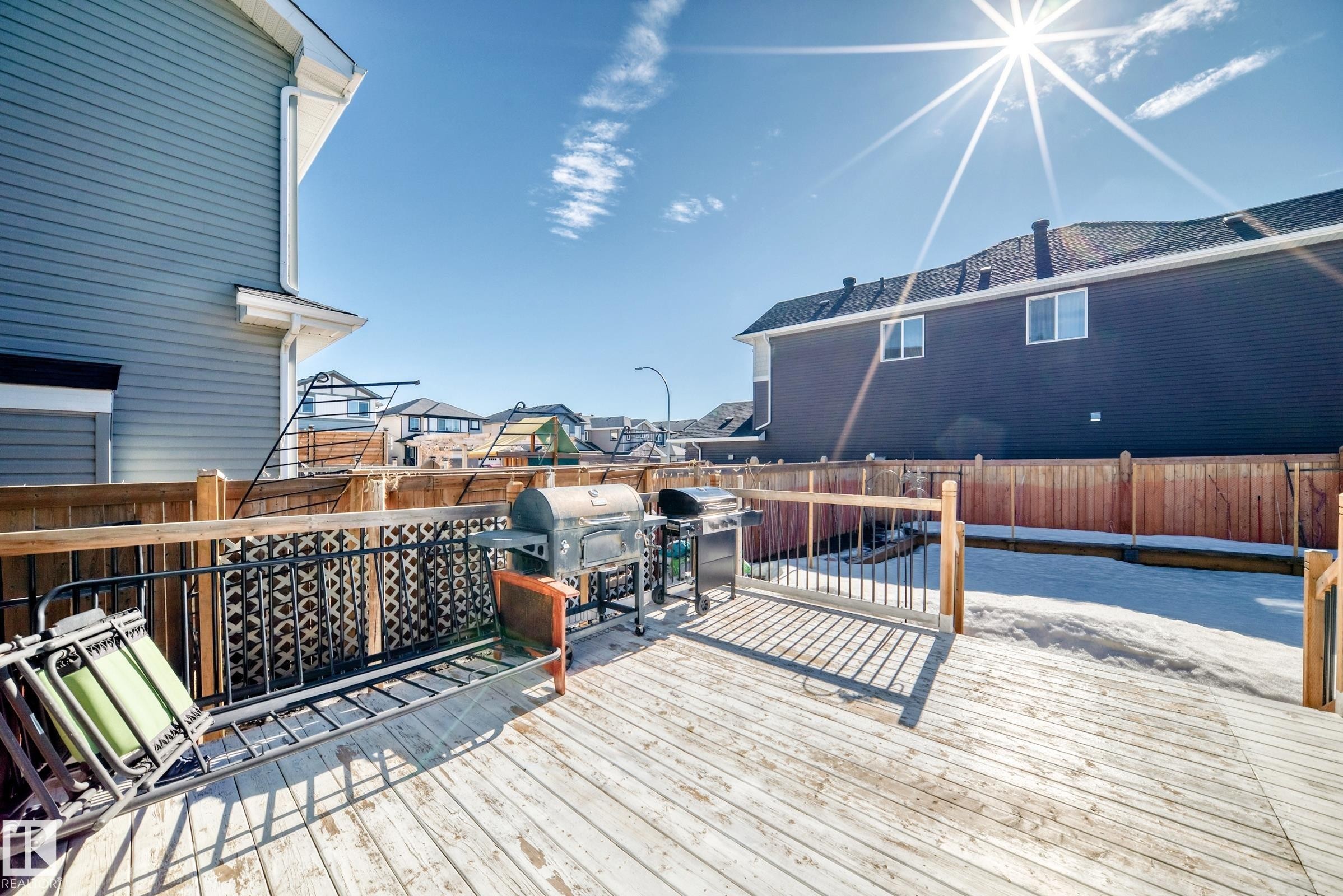 Spacious wooden deck with a detailed metal railing, surrounded by a wooden fence, offering an inviting outdoor area - 22407 99 Avenue, Edmonton, AB - Outdoor With Deck Patio Veranda With Exterior
