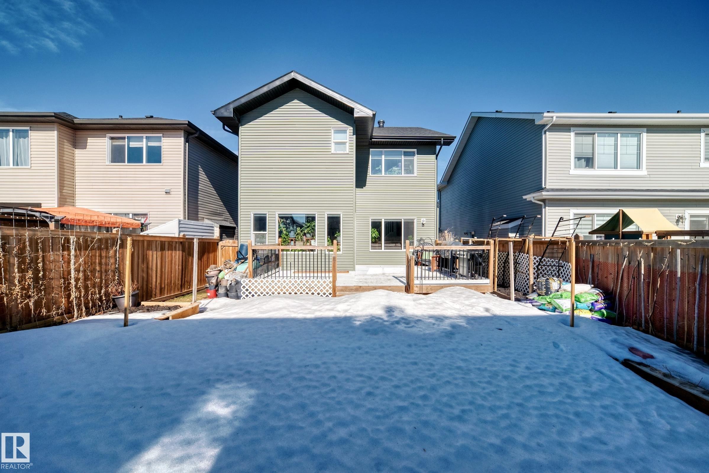 The property features a rear exterior with light green siding and a private fenced yard - 22407 99 Avenue, Edmonton, AB - Outdoor With Deck Patio Veranda