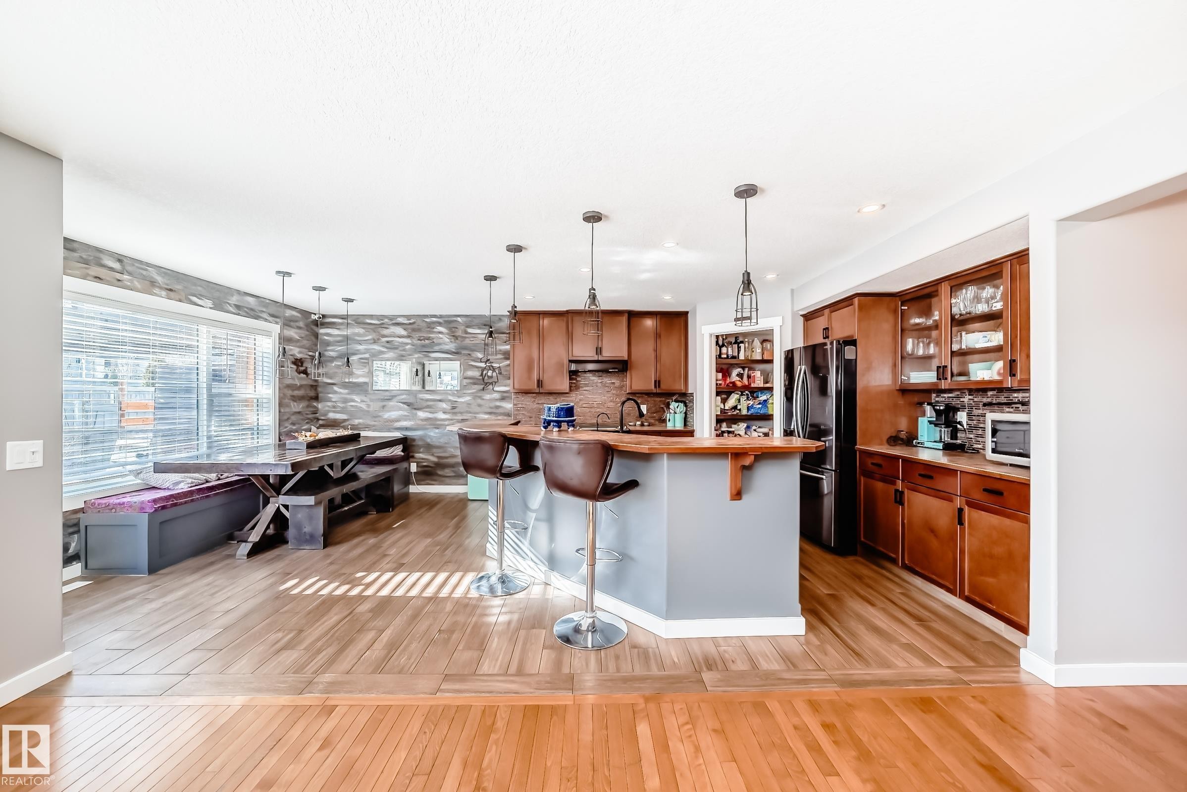 The kitchen features wood cabinetry, a central island with pendant lighting, and a pantry - 6303 2 Avenue, Edmonton, AB - Indoor Photo Showing Kitchen With Upgraded Kitchen