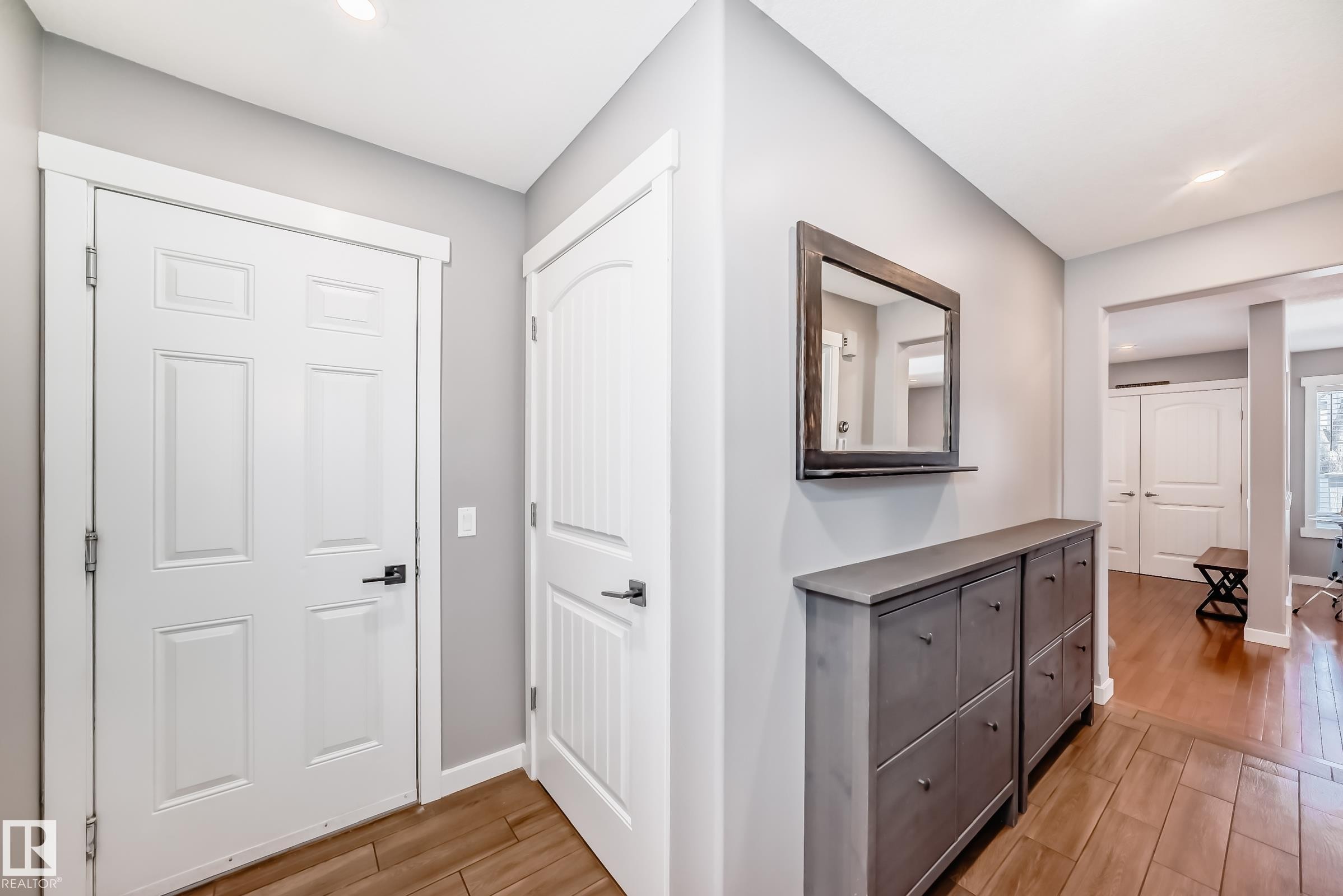 The entryway features light grey walls, white doors, and wood-look tile flooring - 6303 2 Avenue, Edmonton, AB - Indoor Photo Showing Other Room