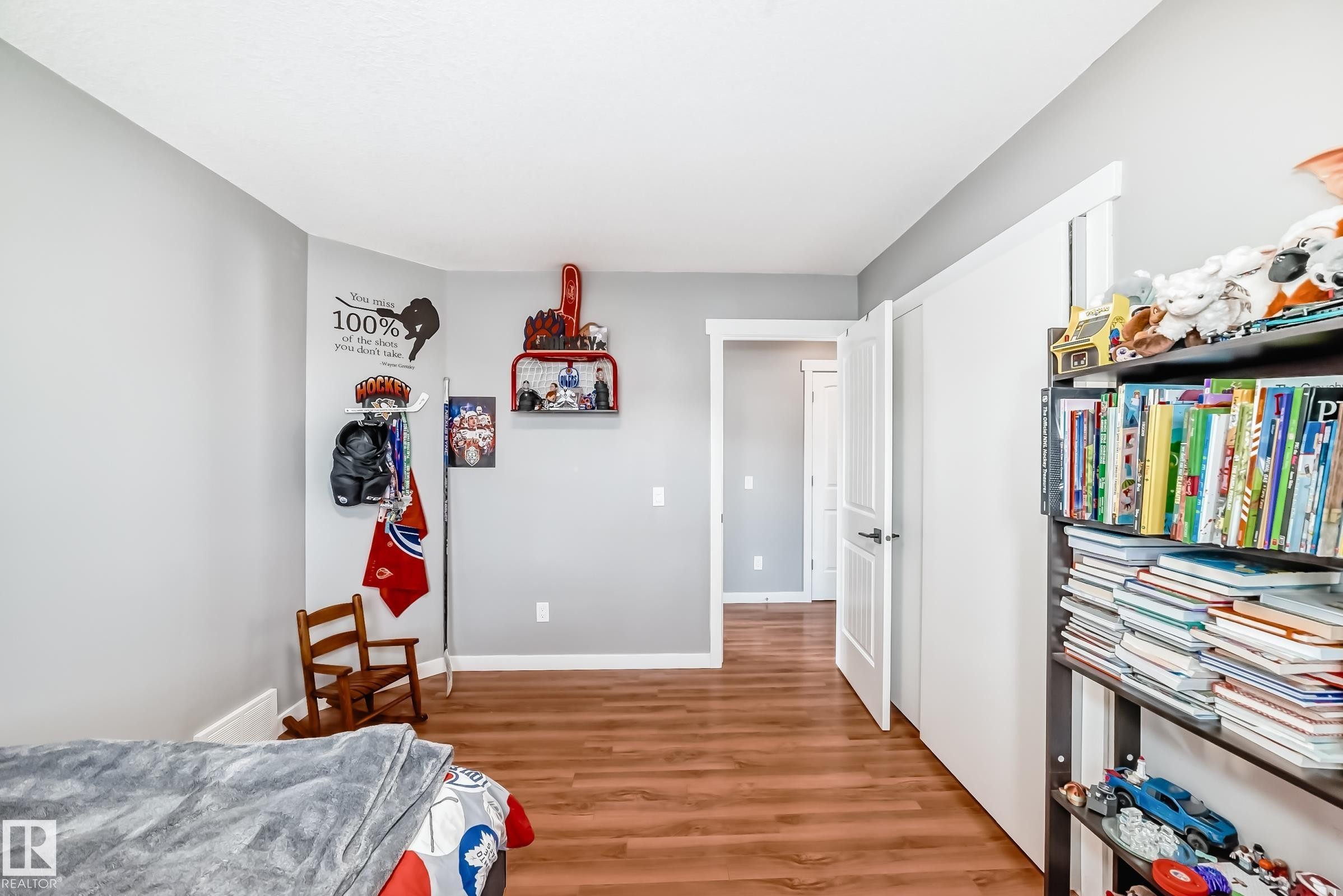 The room features wood-style flooring and light grey walls, with white trim around the doorways and baseboards - 6303 2 Avenue, Edmonton, AB - Indoor Photo Showing Bedroom