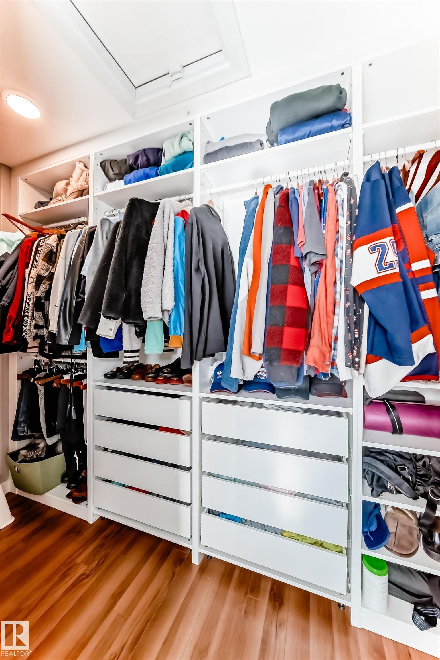 Custom closet system featuring white shelving, drawers with silver hardware, and hardwood floors - 6303 2 Avenue, Edmonton, AB - Indoor With Storage