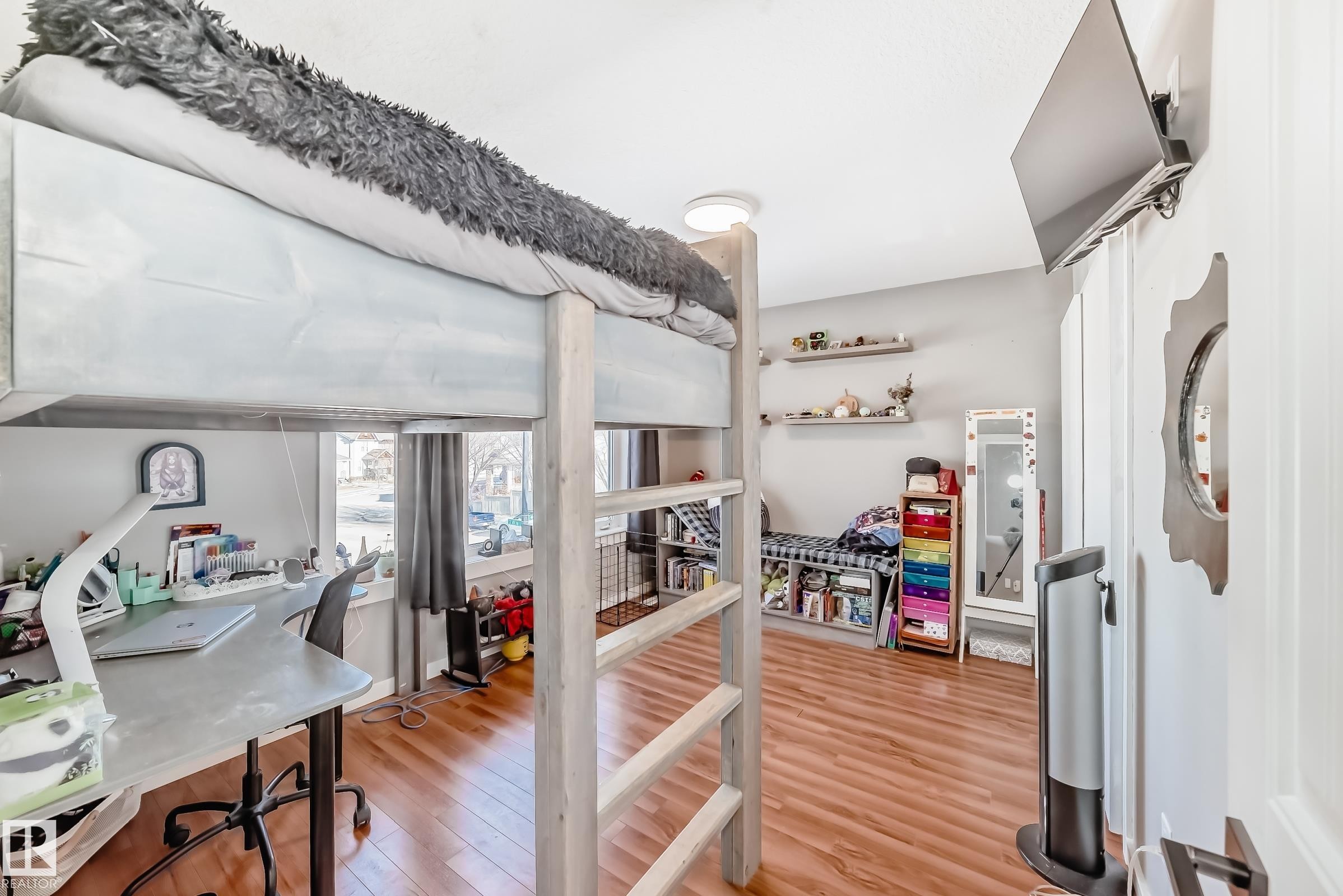 This room features wood flooring and a wall-mounted television - 6303 2 Avenue, Edmonton, AB - Indoor