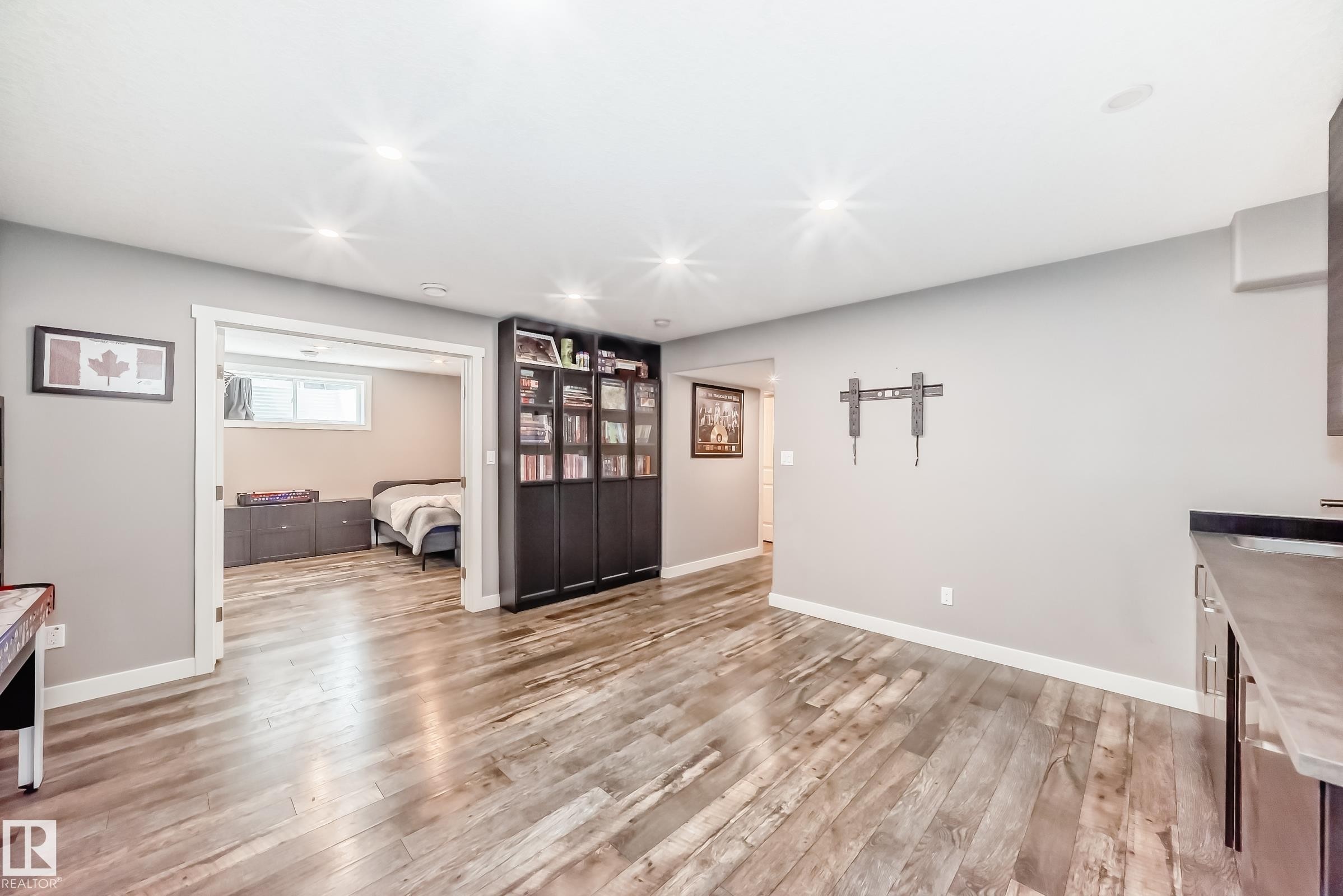 This versatile space features wood-style flooring and recessed lighting, offering a bright and functional area - 6303 2 Avenue, Edmonton, AB - Indoor
