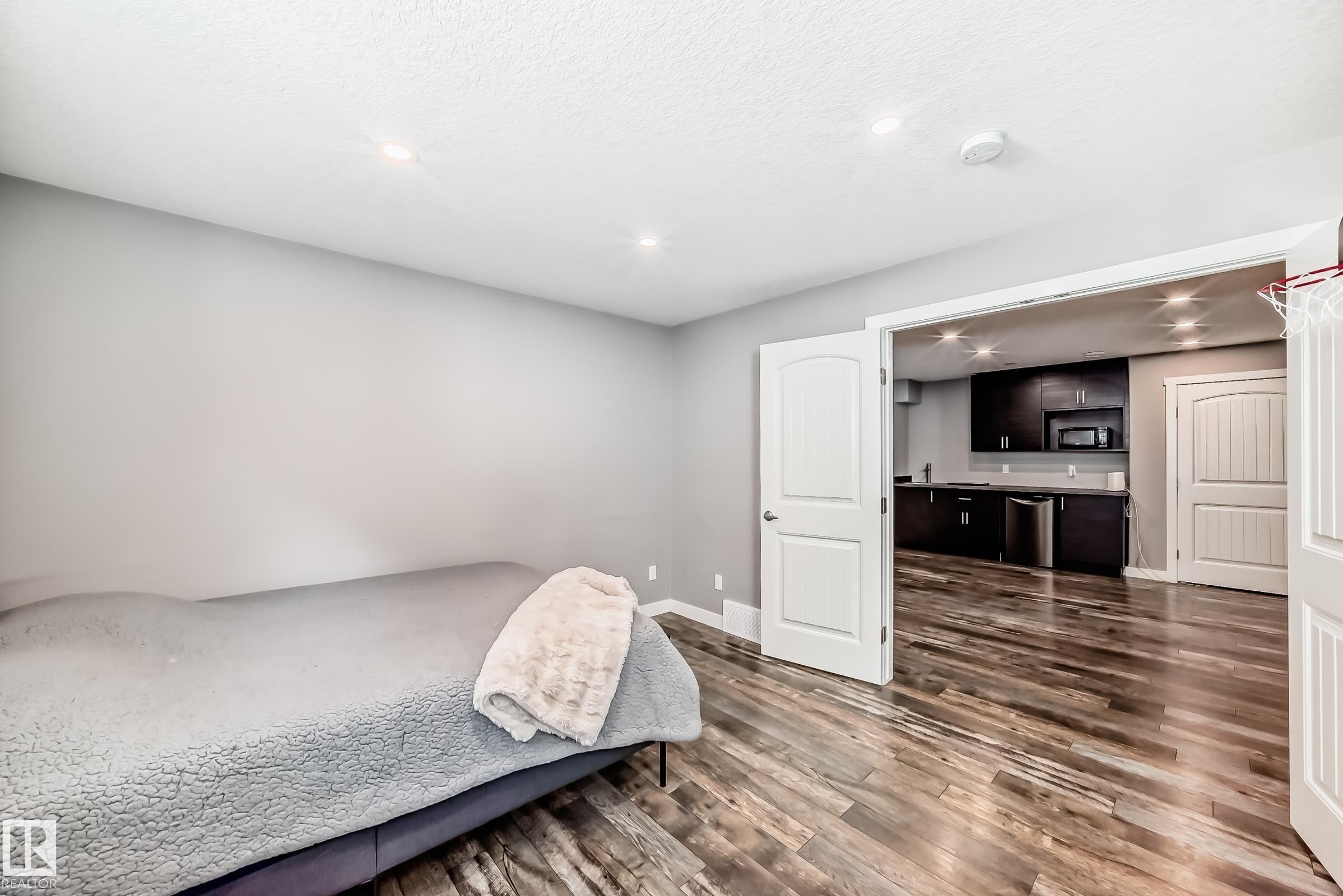 This room features recessed lighting, light gray walls, and wood-look flooring - 6303 2 Avenue, Edmonton, AB - Indoor