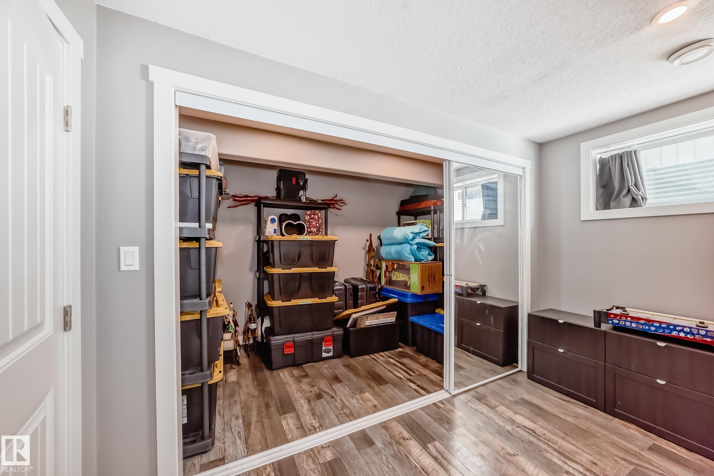 The room features wood-look flooring and light grey walls - 6303 2 Avenue, Edmonton, AB - Indoor