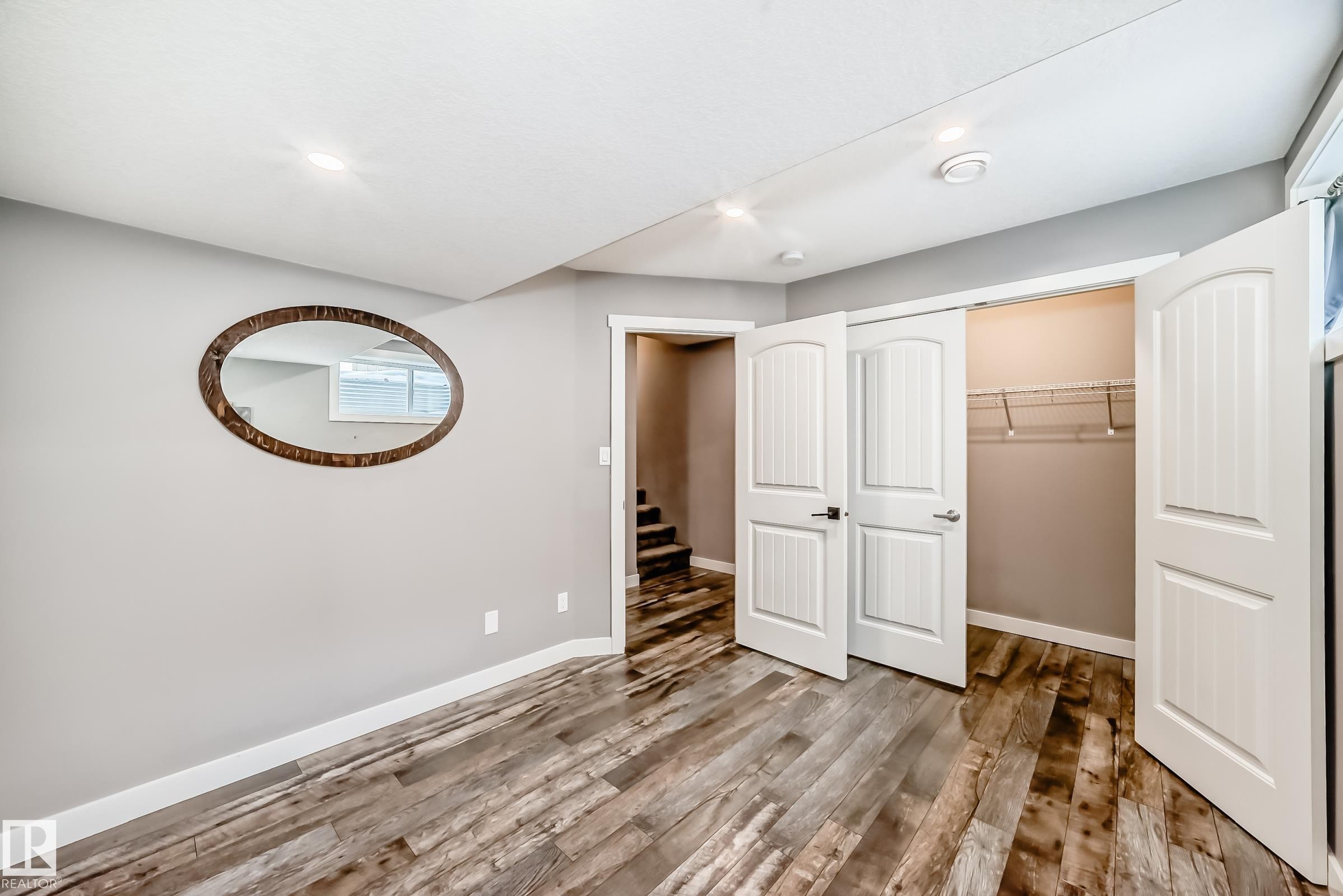 This room features wood-look flooring, light gray walls, and white trim - 6303 2 Avenue, Edmonton, AB - Indoor Photo Showing Other Room