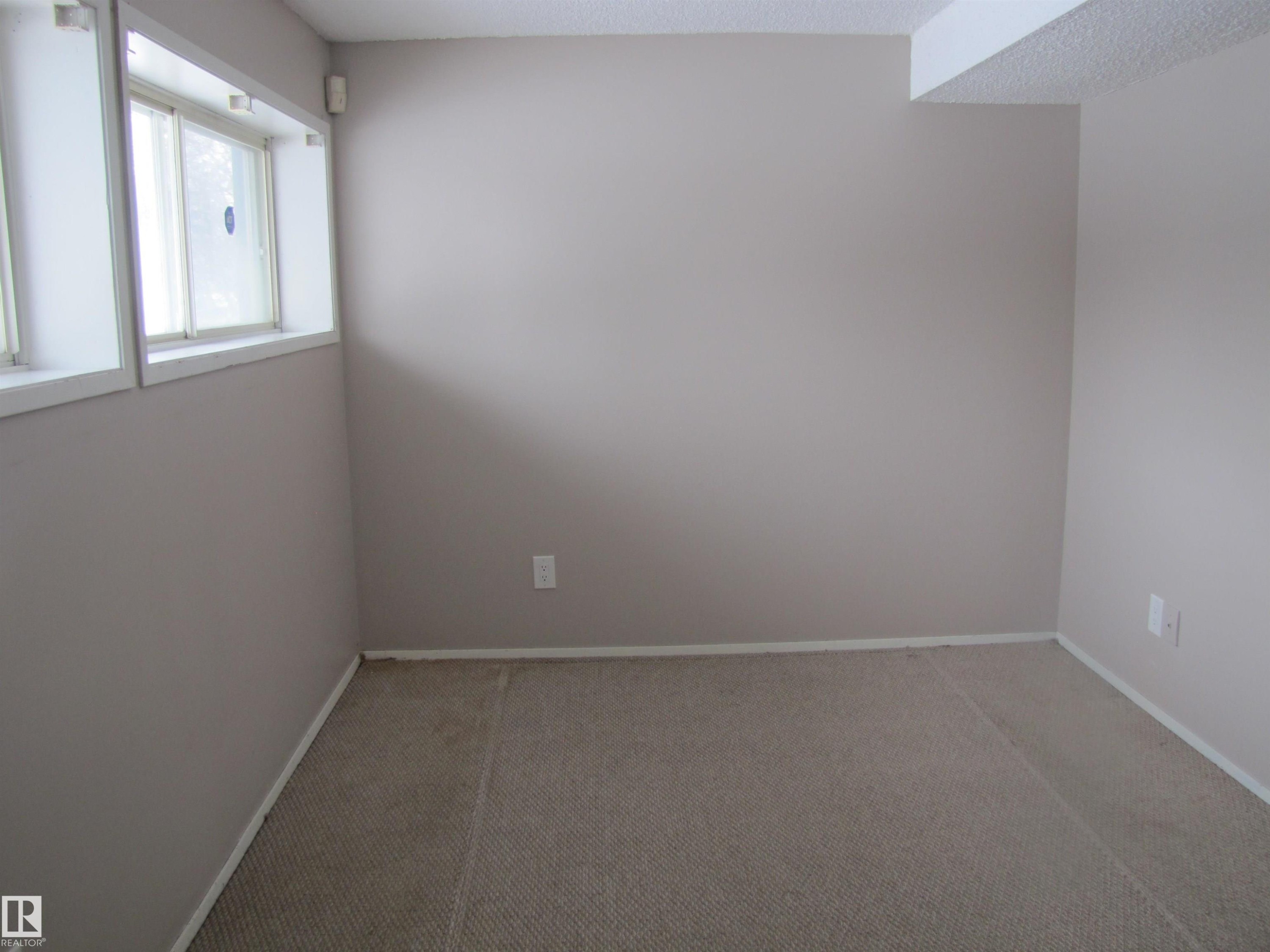 This space features neutral-toned walls, carpeted flooring, and a window providing natural light - 3617 43A Avenue, Edmonton, AB - Indoor Photo Showing Other Room