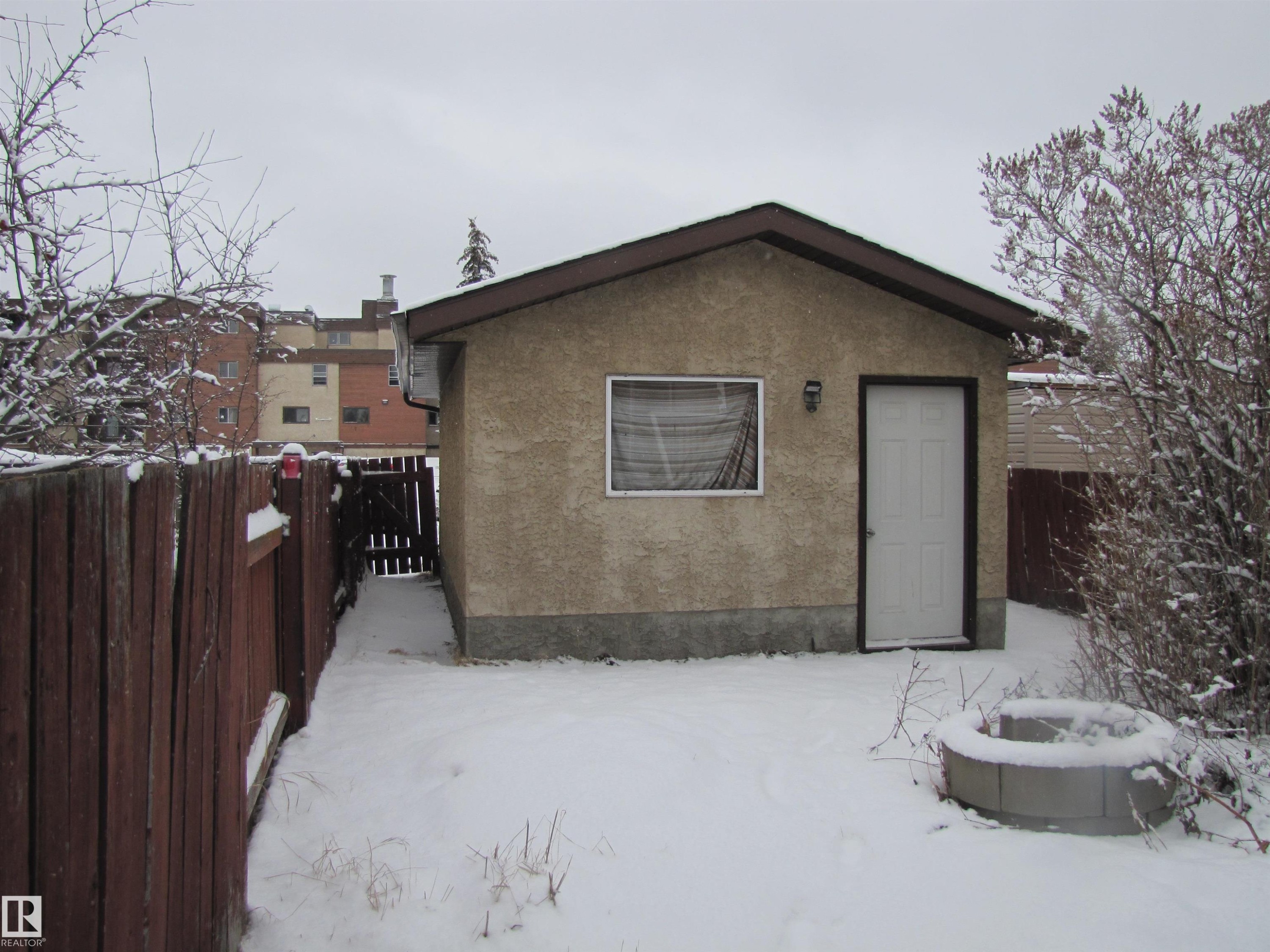 The property features a detached structure with a white door and a window, situated in a fenced yard - 3617 43A Avenue, Edmonton, AB - Outdoor