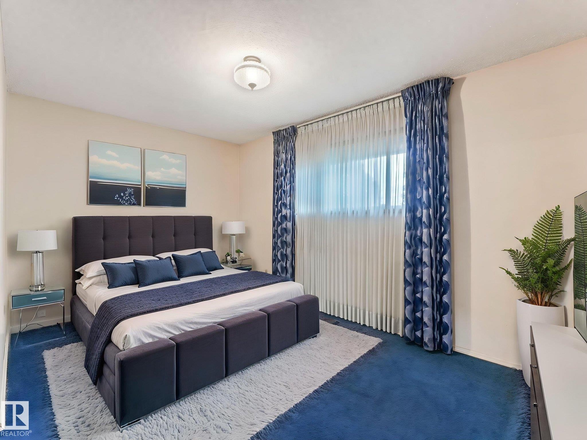 This room features blue carpeting, white walls, and a window with sheer and patterned blue curtains - 5904 84 Avenue, Edmonton, AB - Indoor Photo Showing Bedroom