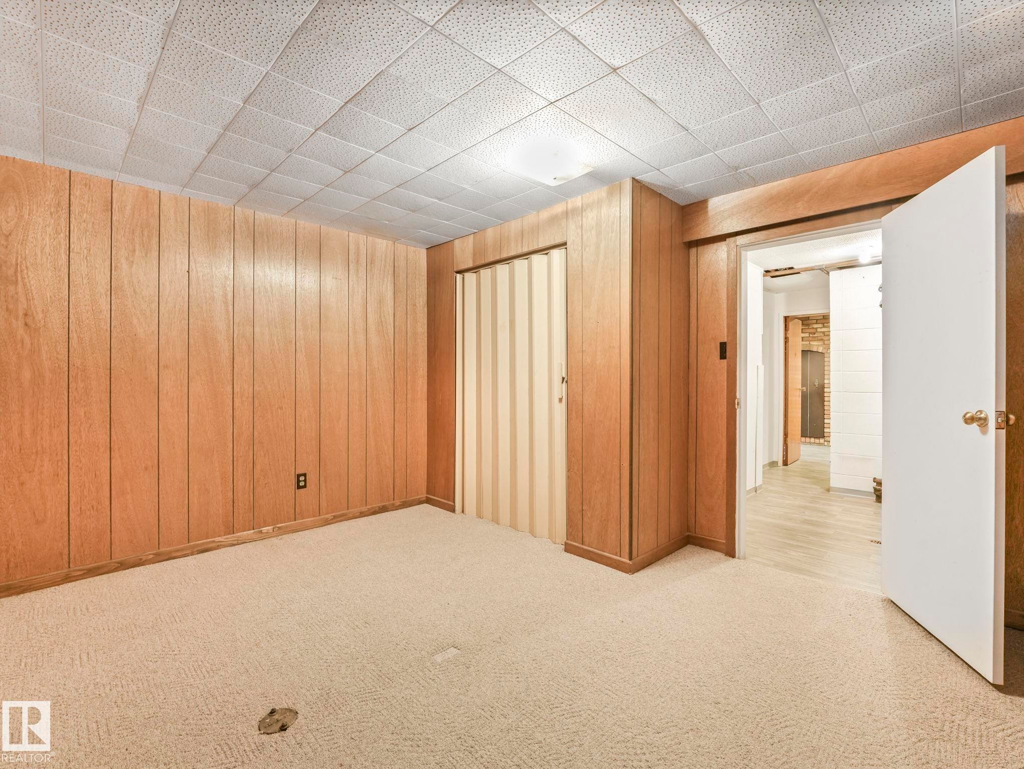 This room features wood paneling, a textured ceiling, and light-colored carpeting - 5904 84 Avenue, Edmonton, AB - Indoor Photo Showing Other Room