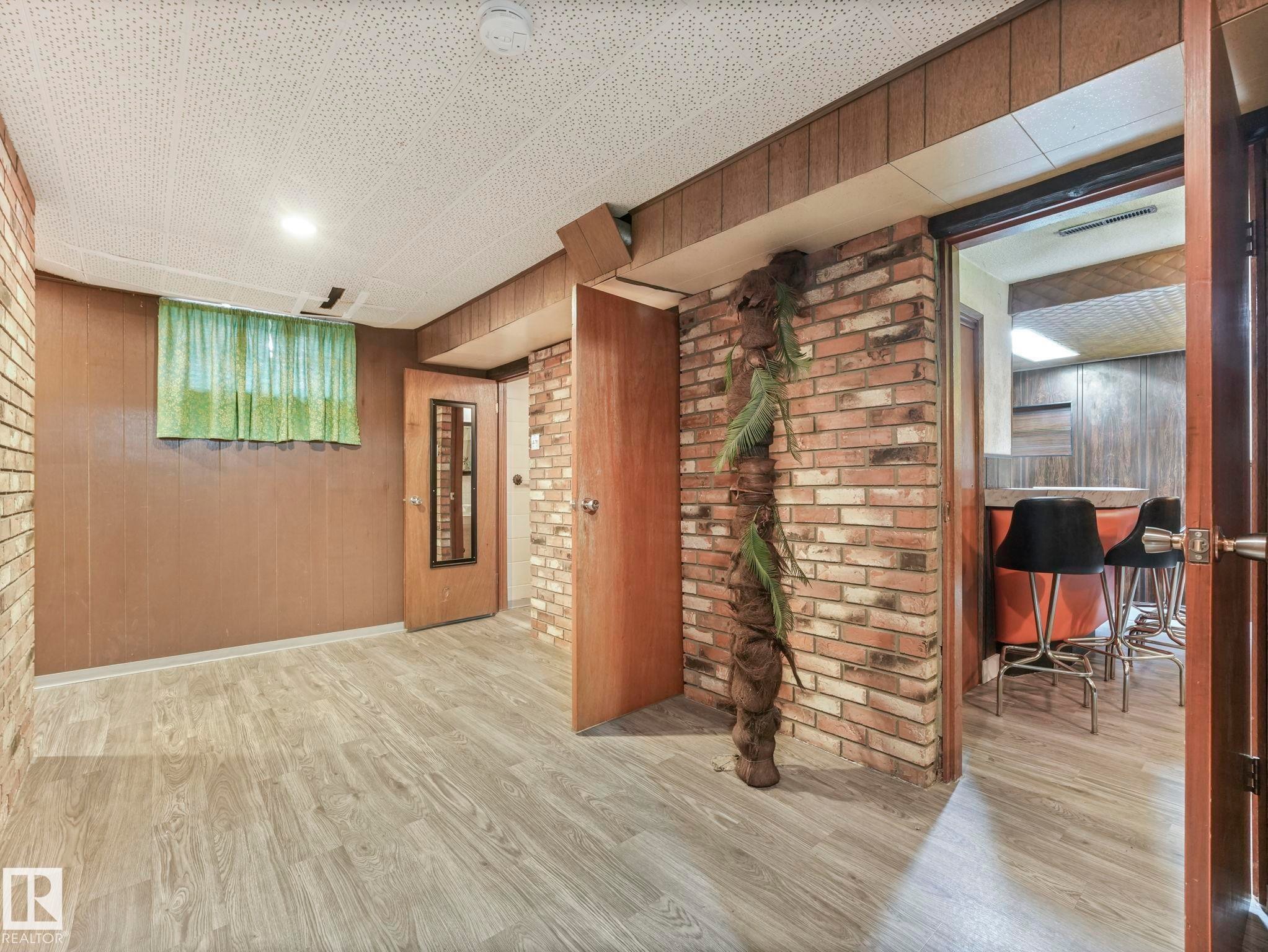 This versatile space features wood paneling and brick accents, creating a distinctive atmosphere - 5904 84 Avenue, Edmonton, AB - Indoor