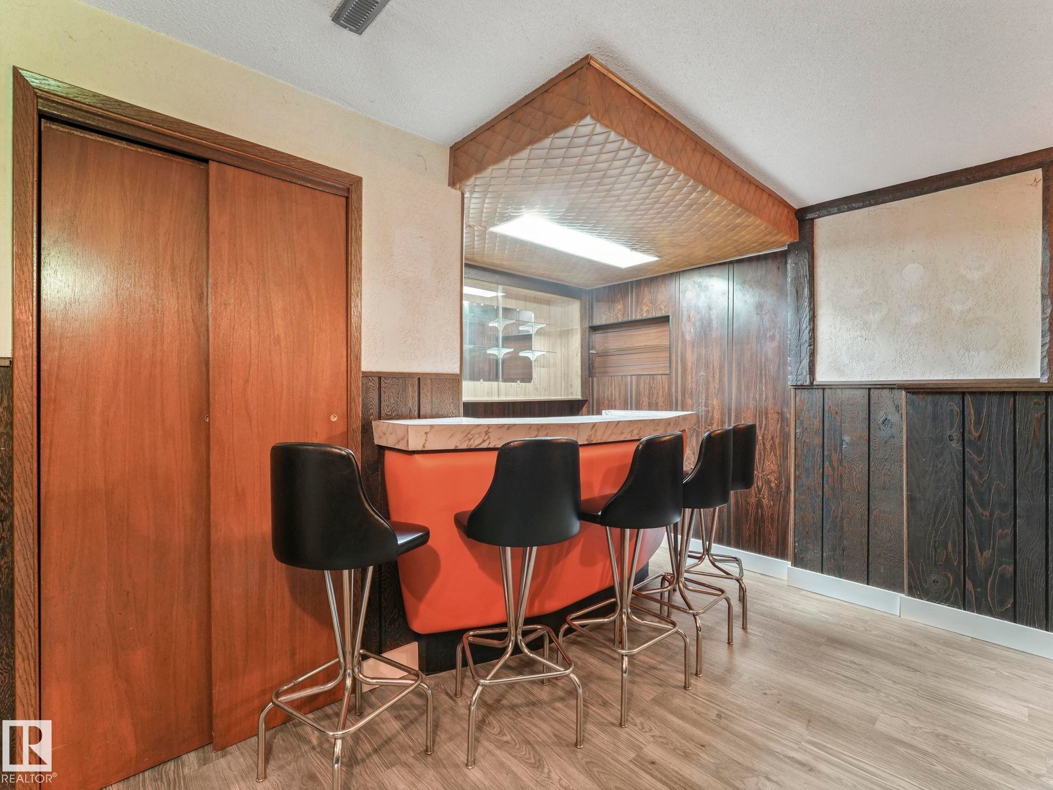 Recreational area featuring wood paneling, a built-in bar, and light-colored flooring - 5904 84 Avenue, Edmonton, AB - Indoor Photo Showing Dining Room