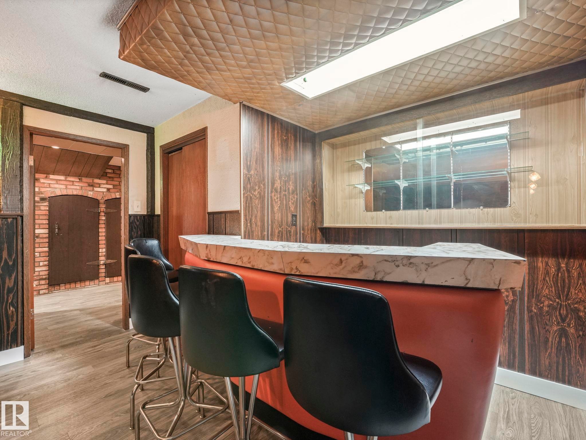 Recreational space featuring a built-in bar with a marble-look countertop and wood paneling - 5904 84 Avenue, Edmonton, AB - Indoor Photo Showing Office