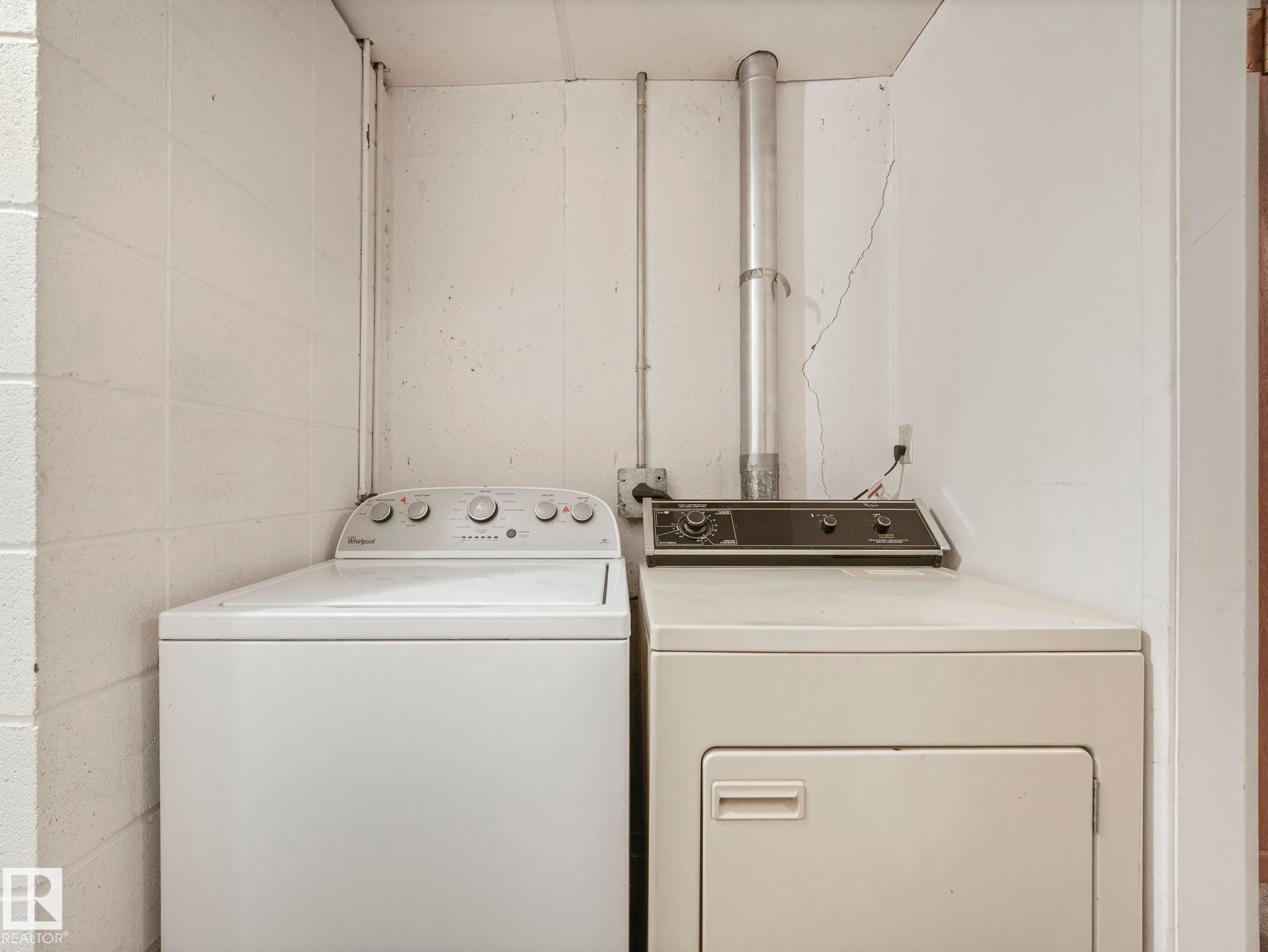 Laundry area featuring a top-loading washing machine and a front-loading dryer - 5904 84 Avenue, Edmonton, AB - Indoor Photo Showing Laundry Room