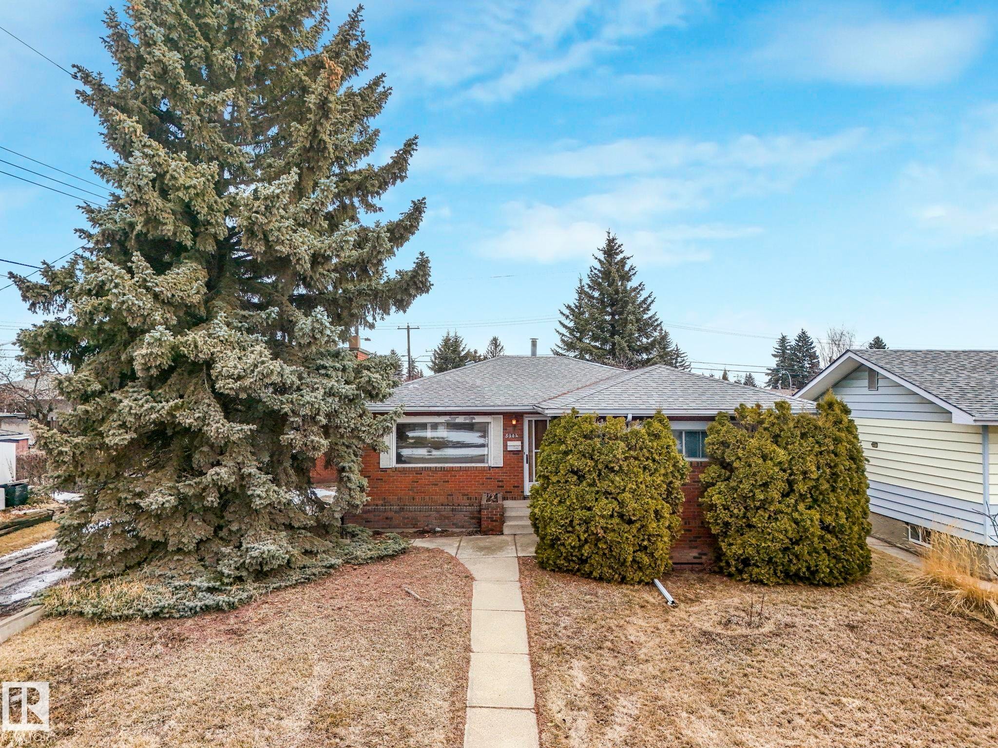 The property features a brick exterior, a grey shingled roof, and a paved walkway leading to the entrance - 5904 84 Avenue, Edmonton, AB - Outdoor