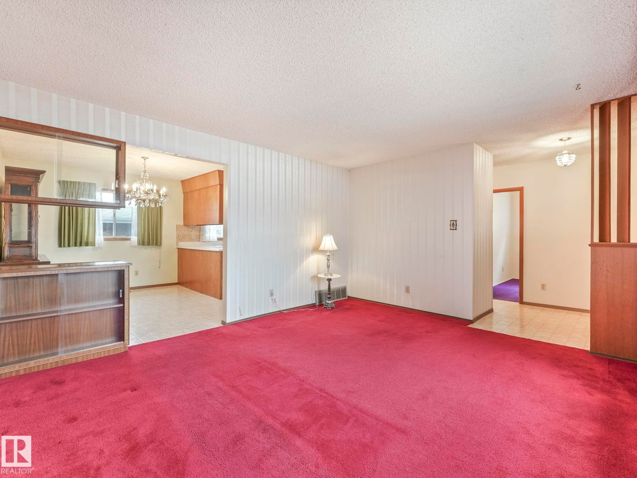 The living area features red carpeting and white walls, with a partial wood partition - 5904 84 Avenue, Edmonton, AB - Indoor Photo Showing Other Room