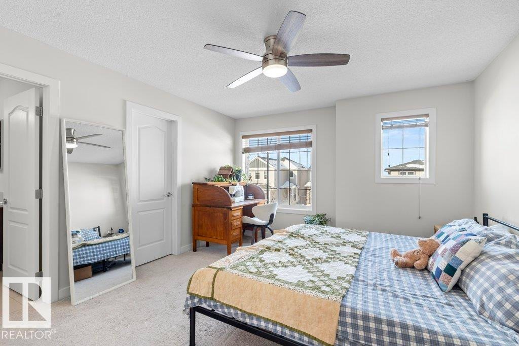 This room features light-colored carpeting, white walls, and a ceiling fan with integrated lighting - 1227 Secord Landing, Edmonton, AB - Indoor Photo Showing Bedroom