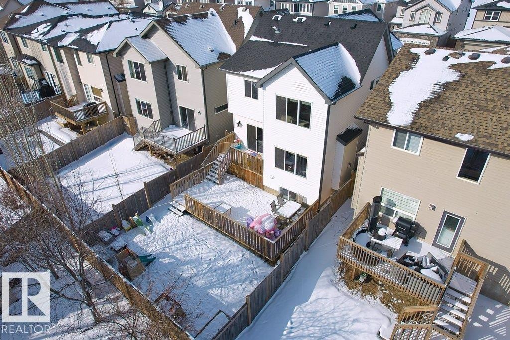 The property features a private backyard with a wooden fence and a raised wooden deck - 1227 Secord Landing, Edmonton, AB - Outdoor