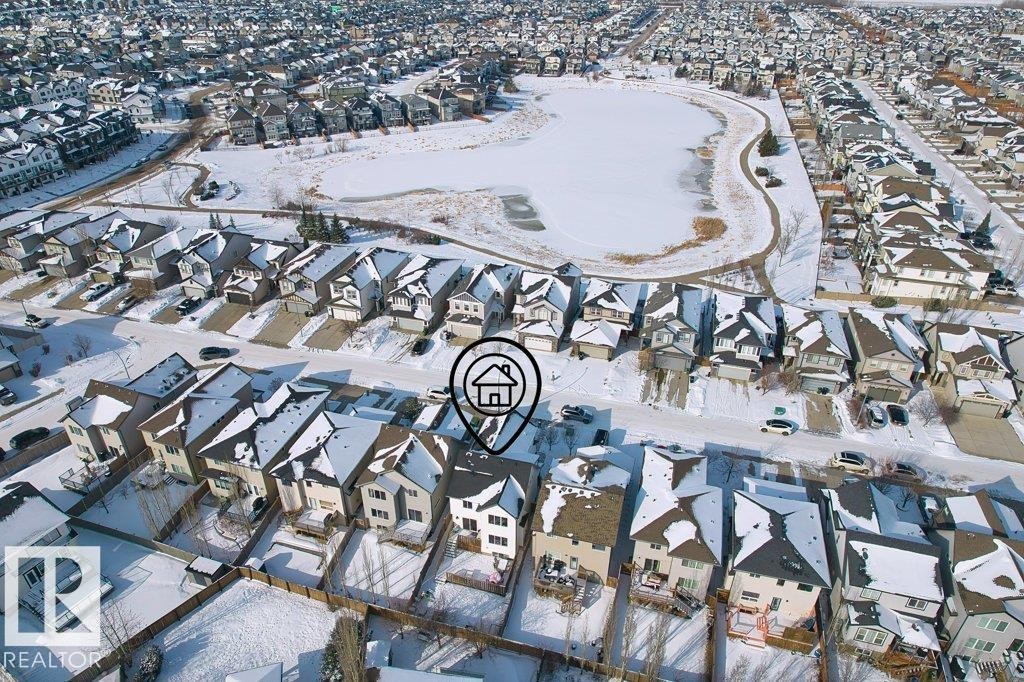 Aerial view of the property and its surrounding neighborhood, featuring a pond and a network of paved roads - 1227 Secord Landing, Edmonton, AB - With View