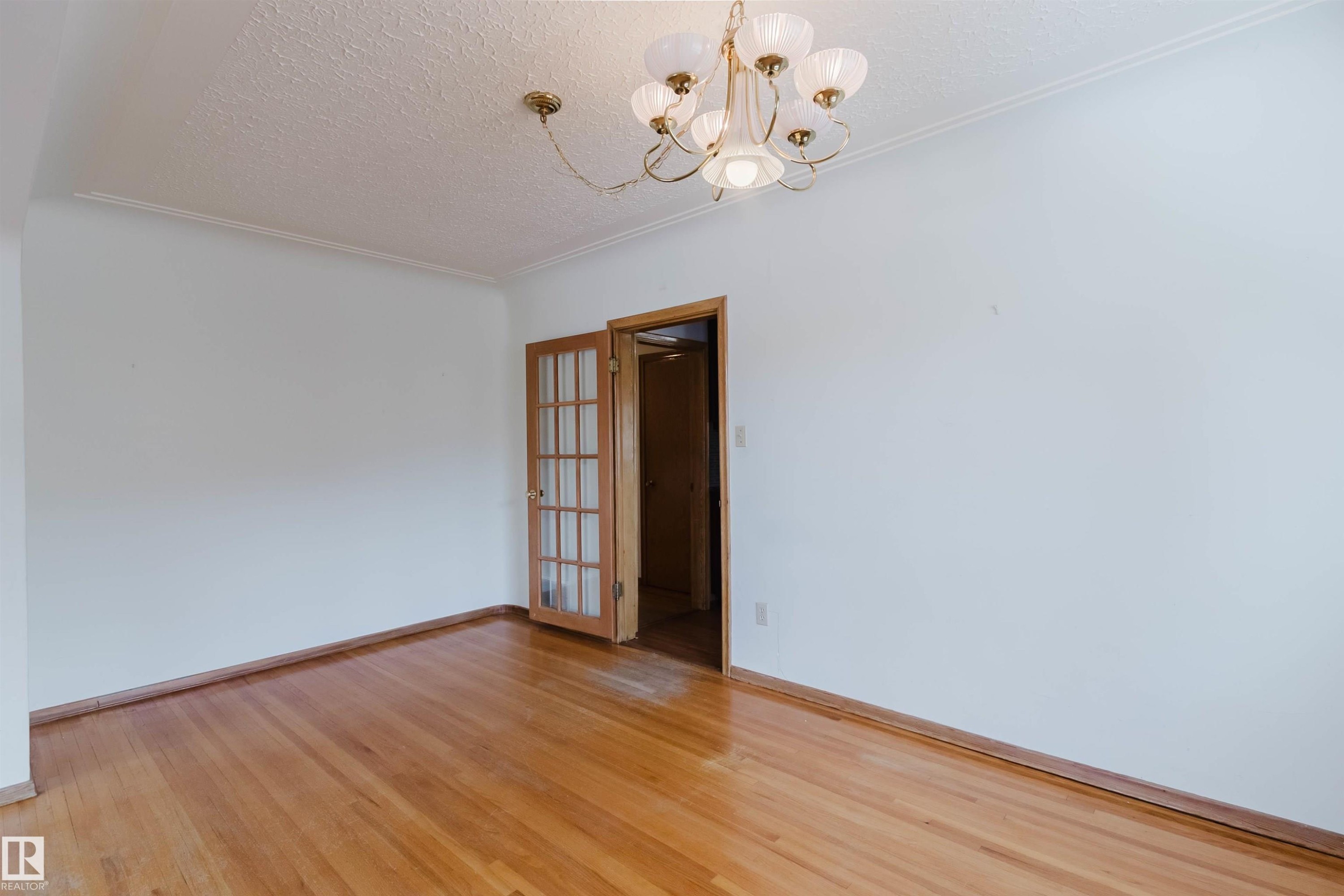 This room features hardwood floors and a chandelier - 11815 76 Avenue, Edmonton, AB - Indoor Photo Showing Other Room