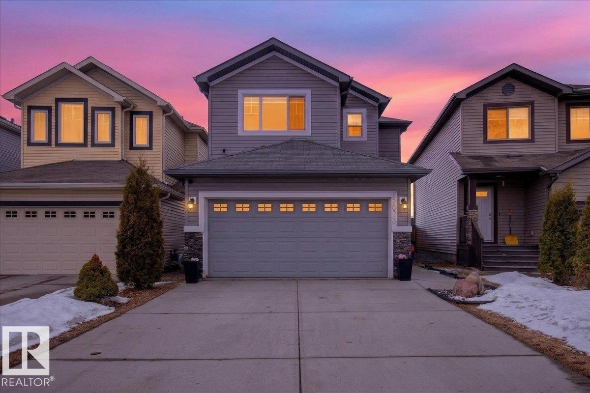 The property features an attached garage with a paved driveway - 17023 38 Street Nw, Edmonton, AB - Outdoor With Facade