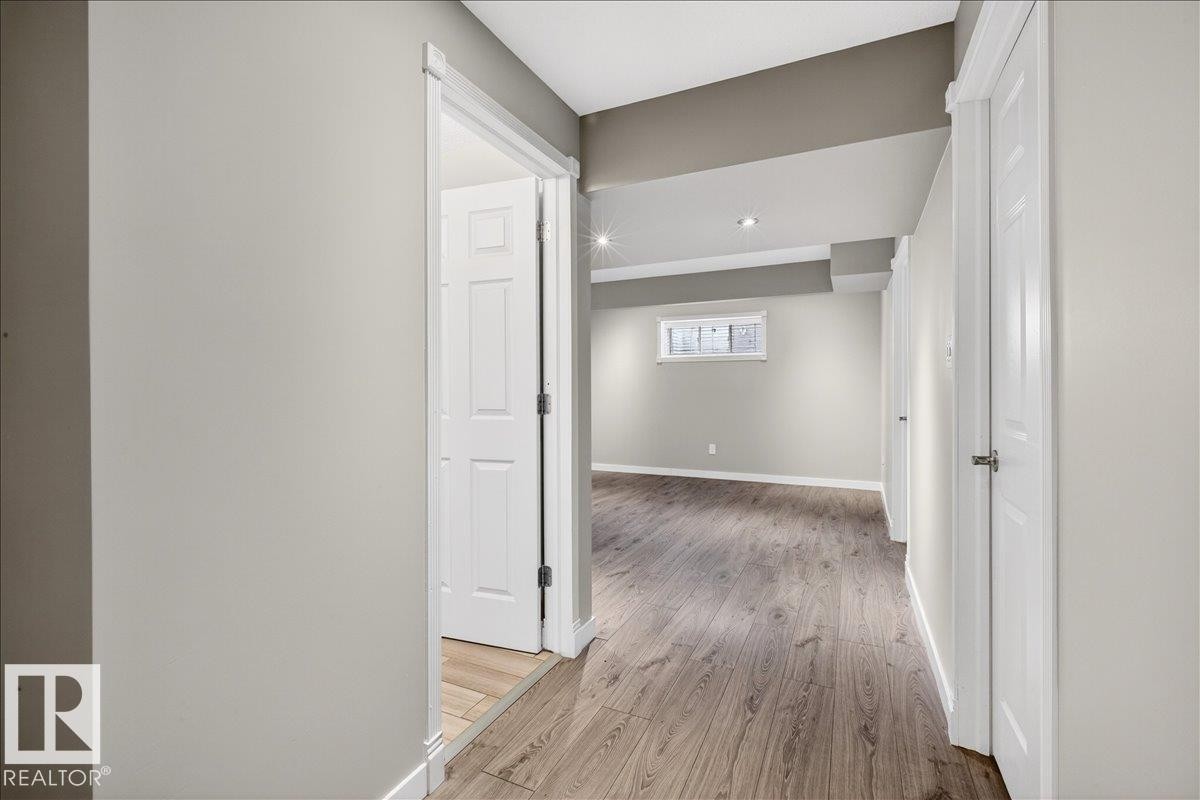 Spacious interior featuring light-colored walls, wood-style flooring, and recessed lighting - 17023 38 Street Nw, Edmonton, AB - Indoor Photo Showing Other Room