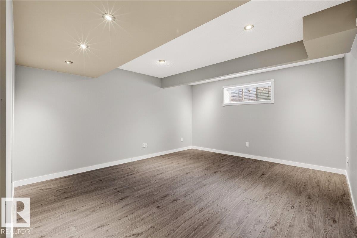 Versatile room featuring light grey walls, light wood-look flooring, recessed lighting, and a window with blinds - 17023 38 Street Nw, Edmonton, AB - Indoor Photo Showing Other Room