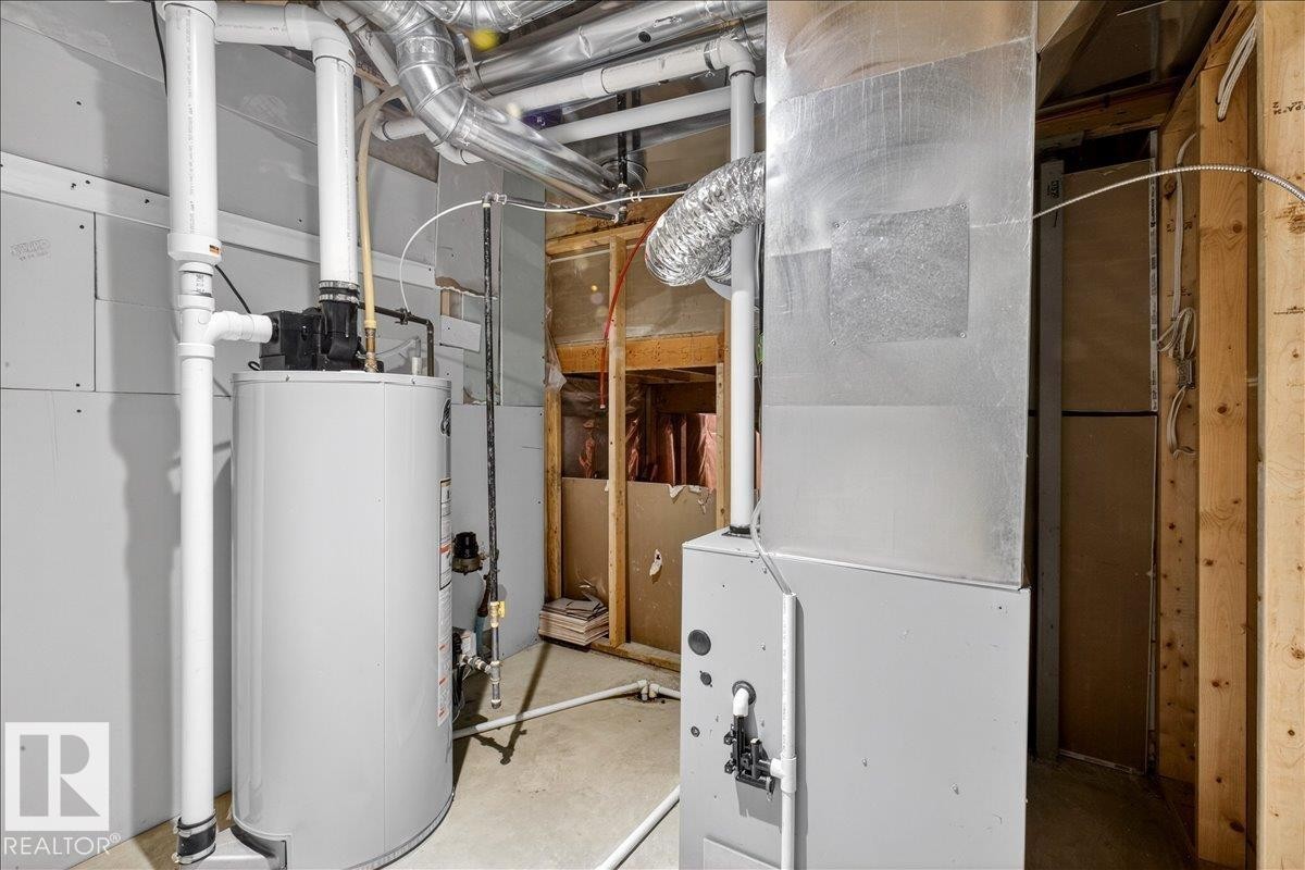 The utility area includes a water heater and furnace, along with exposed ductwork and piping - 17023 38 Street Nw, Edmonton, AB - Indoor Photo Showing Basement
