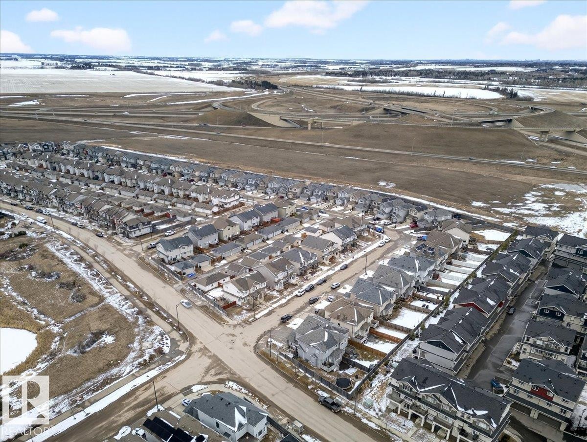 Aerial view of the community, showcasing streets, residential properties, and surrounding fields - 17023 38 Street Nw, Edmonton, AB - Outdoor With View