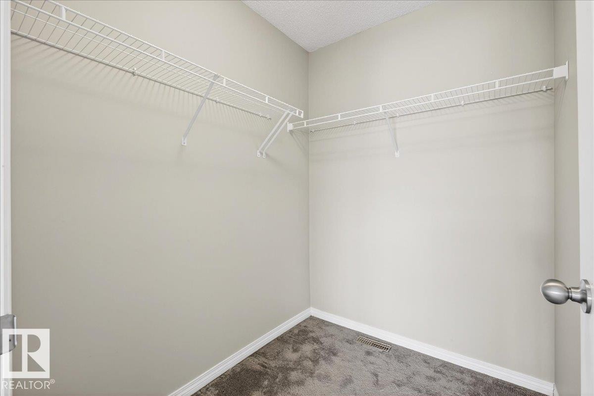 The property features a walk-in closet with white wire shelving and grey carpet - 17023 38 Street Nw, Edmonton, AB - Indoor With Storage